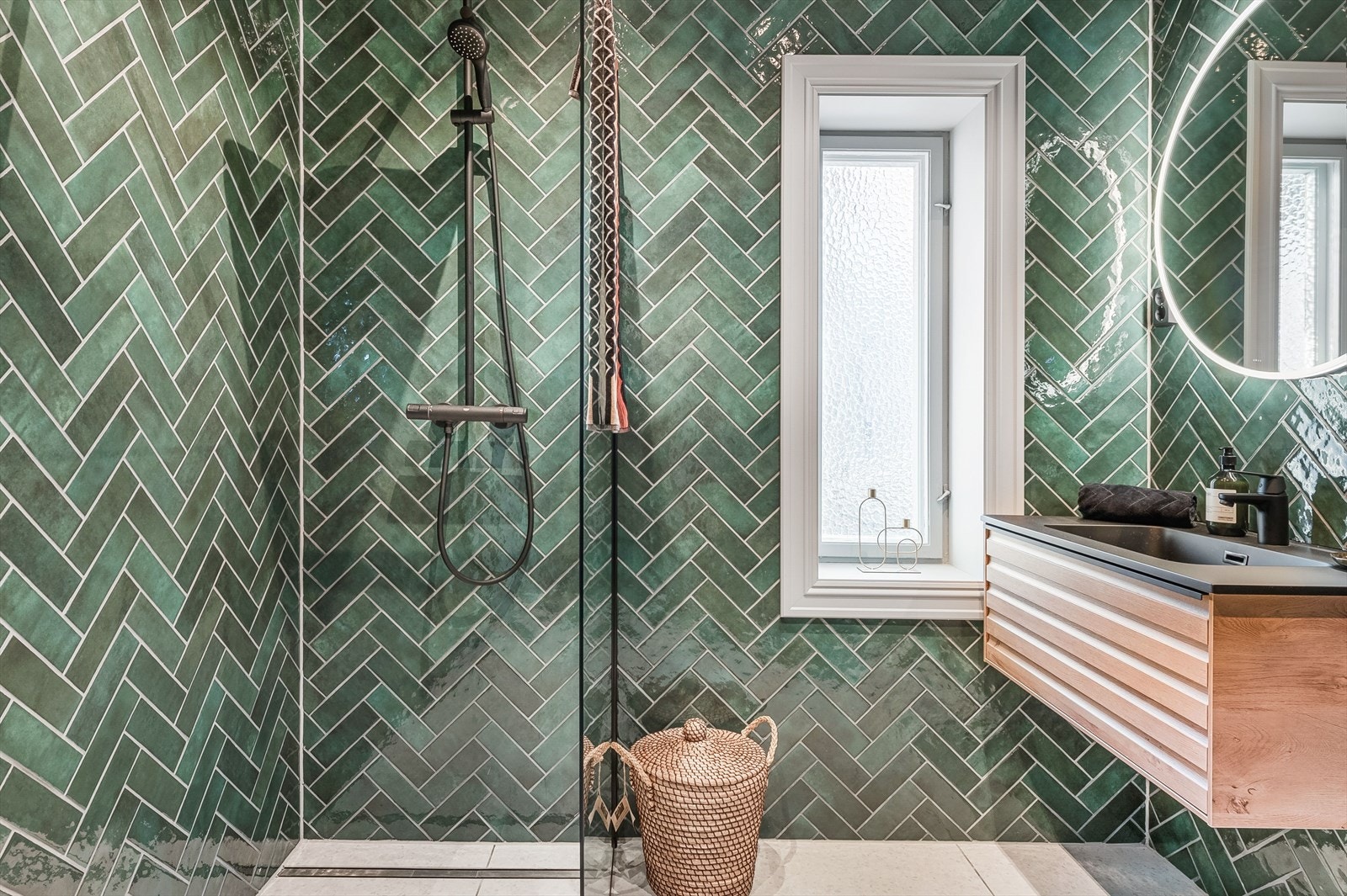 Rommet er utstyrt med vegghengt toalett, en stilren dusjnisje med takdusj som gir spa-følelse i hverdagen, samt en moderne baderomsinnredning med belyst speil over Galleribilde