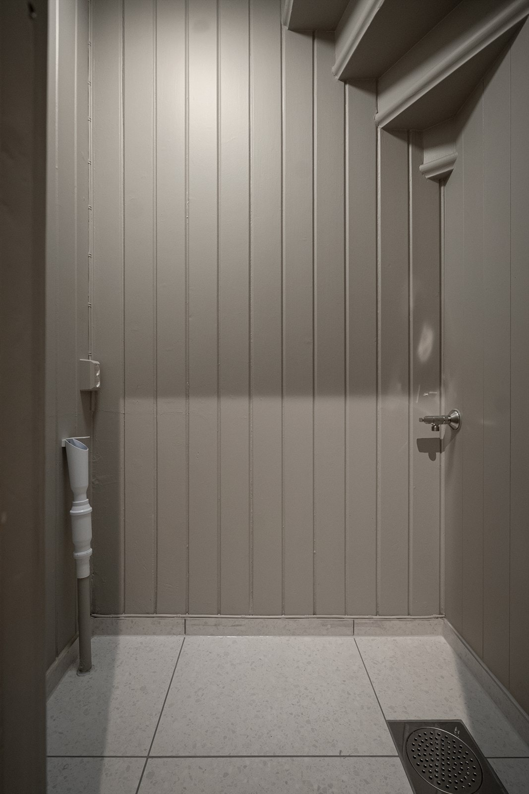 Under trappen finner du en smart og funksjonell bod med flislagt gulv, sluk og opplegg for vaskemaskin Galleribilde