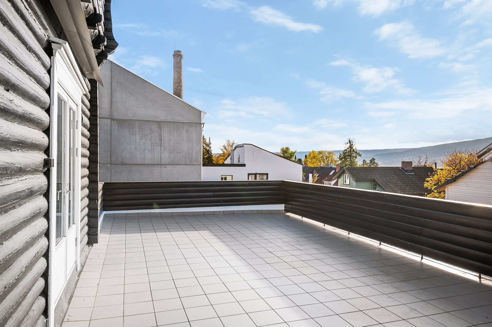 Terrassen har flislagt gulv og et tett rekkverk som gir en lun og privat atmosfære Galleribilde