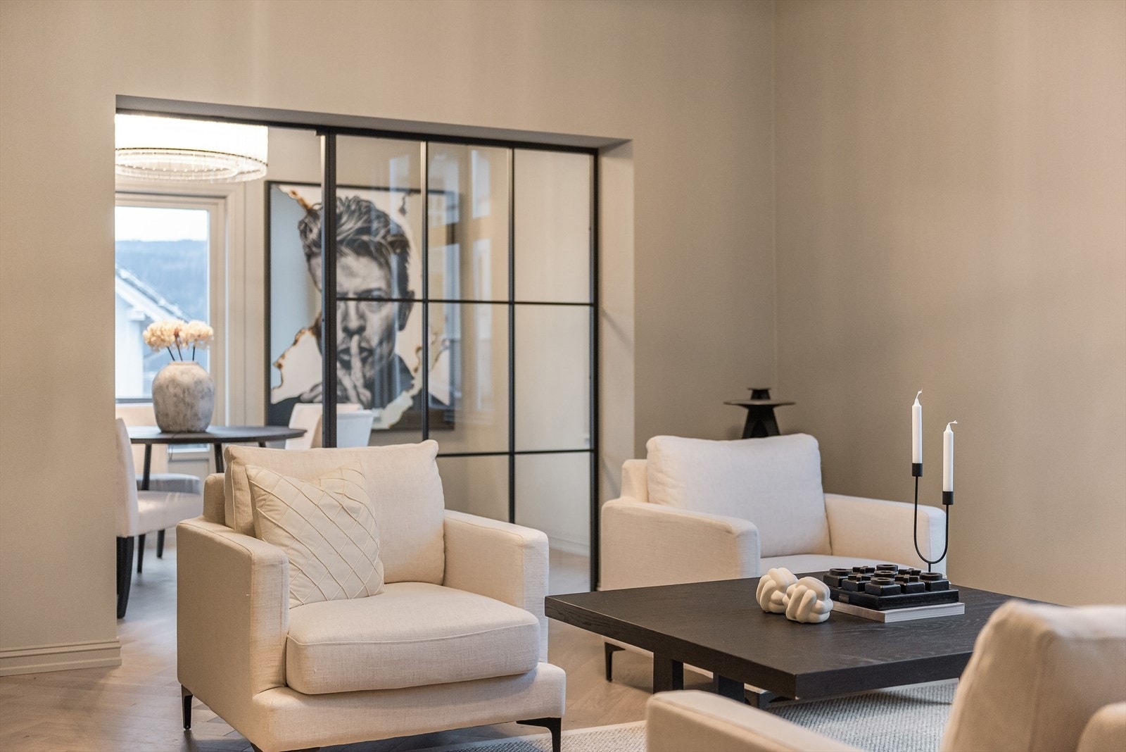 Innenfor hovedstuen finner du en elegant spisestue, smakfullt avdelt med en moderne glassvegg med stilrene sorte detaljer - en løsning som både skaper romfølelse og tilfører et eksklusivt preg Galleribilde