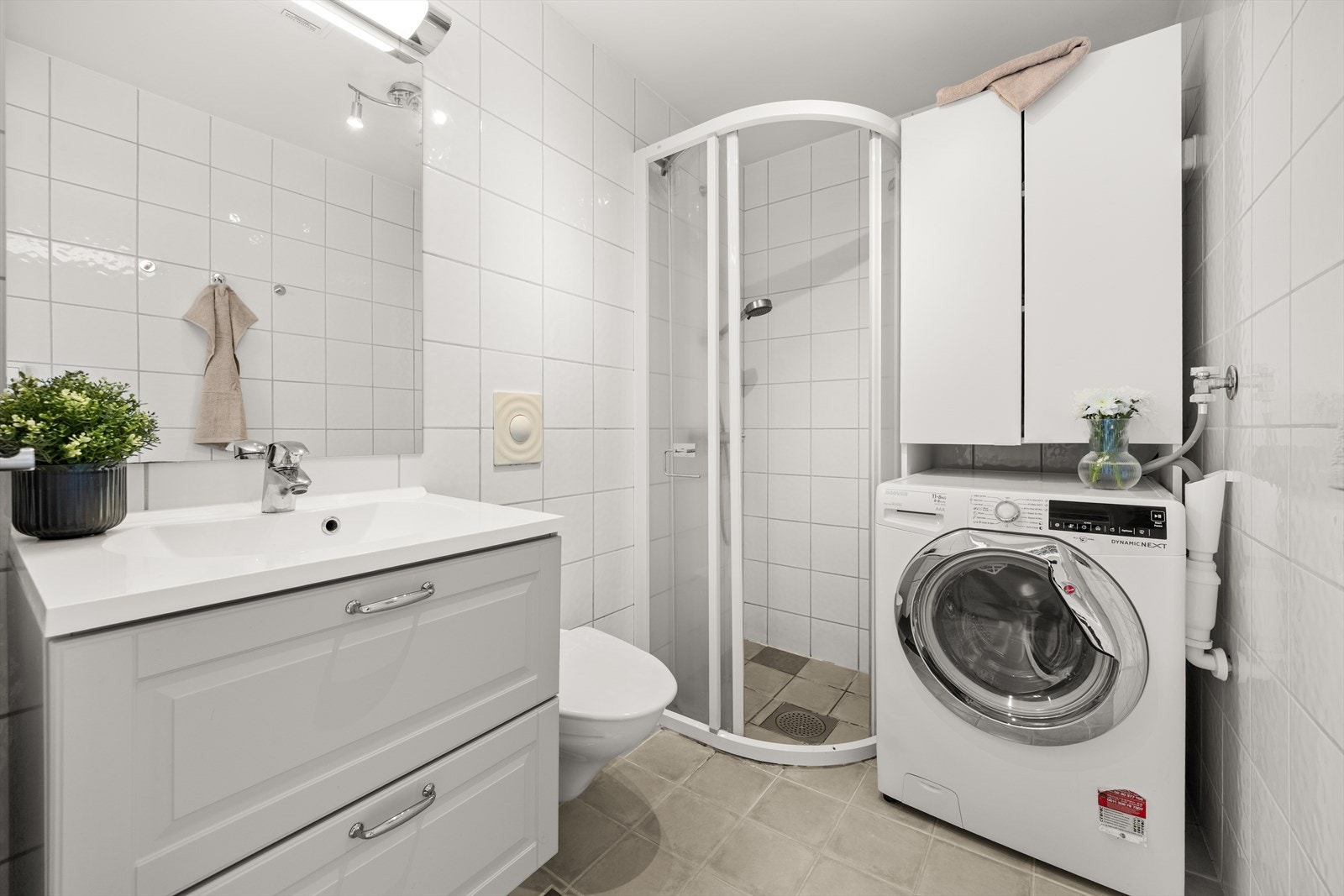 Flislagt bad med varmekabler i gulv - Innredning med plass for vaskemaskin og oppbevaring Galleribilde