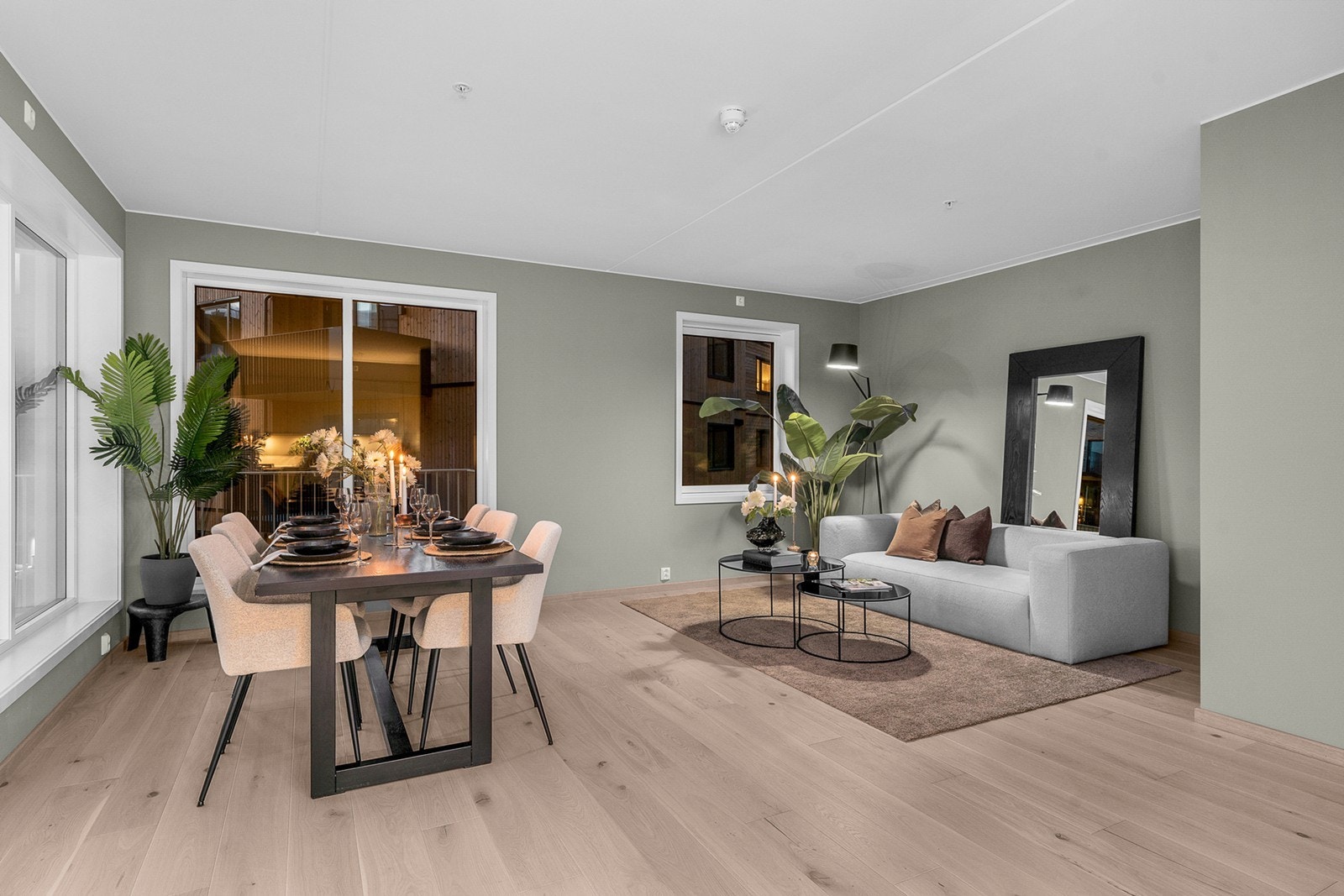 Lys og innbydende stue med åpen kjøkkenløsning og store vindusflater fra to sider som slipper inn rikelig med dagslys Galleribilde