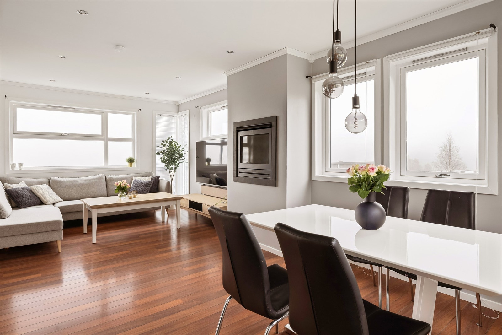 Lys delikat stue med slette vegg og takflater. Spotter i tak. Gasspeis i stue. Galleribilde