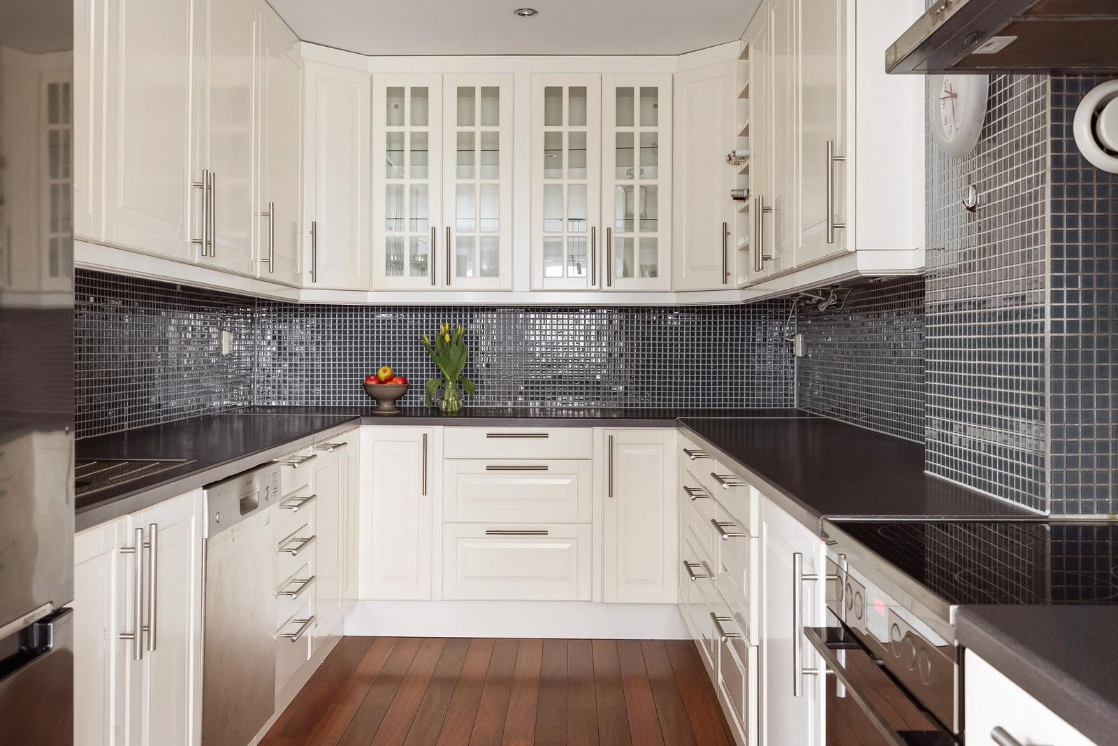 Meget god benke- og skapplass. Takhøye hvite profilerte kjøkkenskap. Fliser mellom benkeplate og overskap. Galleribilde