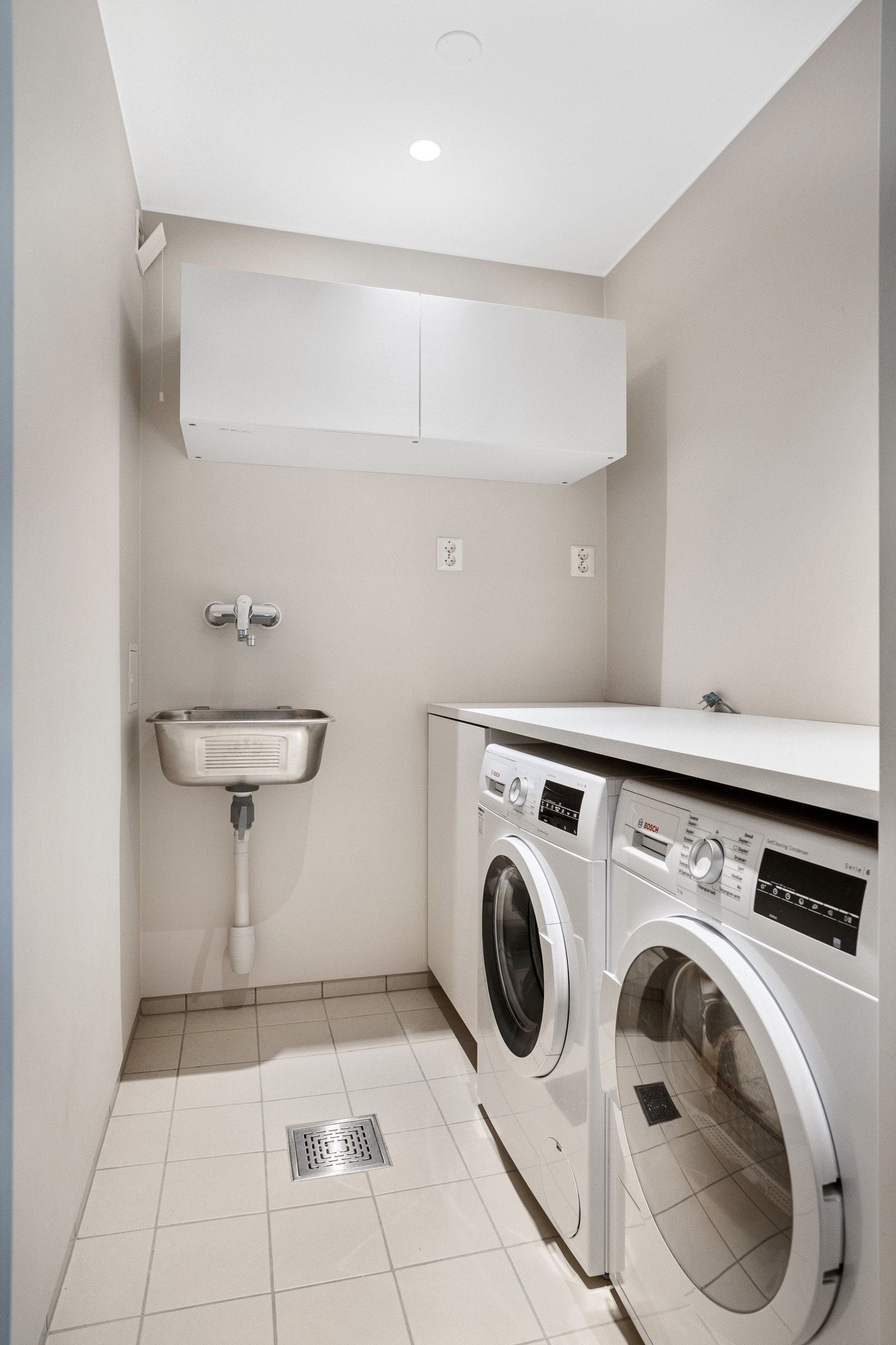 Eget vaskerom er et verdimessig godt element, og letter bruken av baderommet betraktelig. Både vaskemaskin og tørketrommel er godt integrert i rommet med overliggende benkeplate. Galleribilde