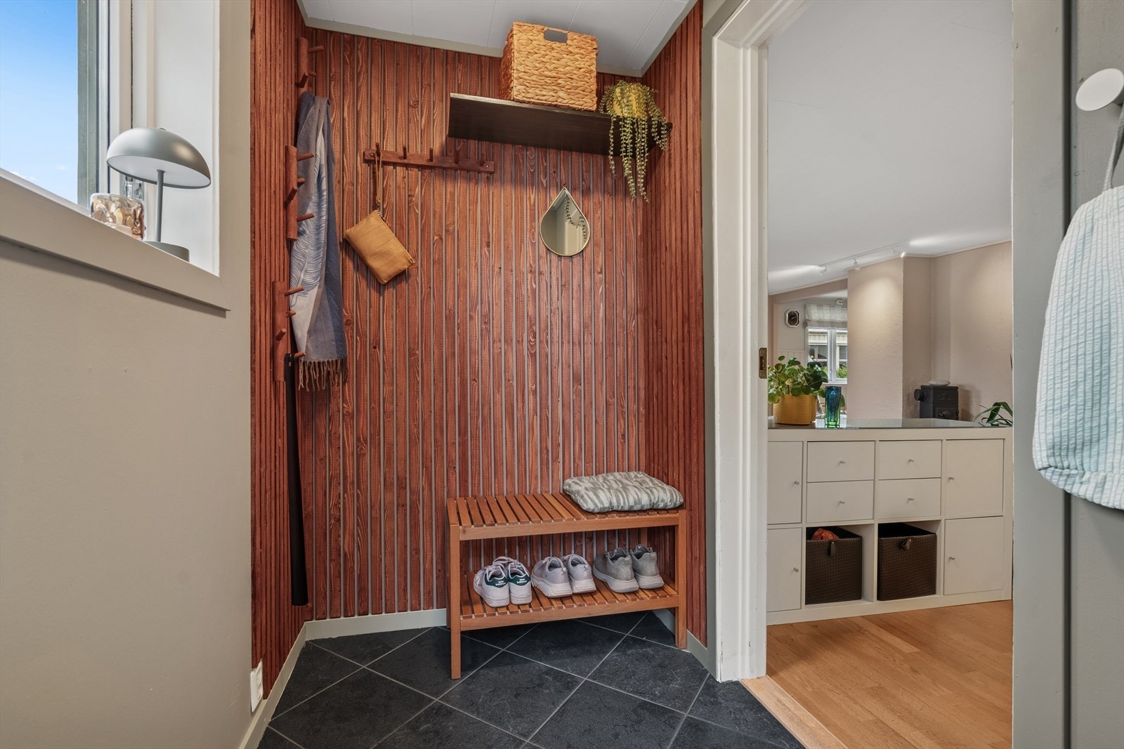 Du ønskes velkommen inn i en hyggelig flislagt entrè m/gulvvarme - Entreen er utstyrt med knagger, hattehylle og skohylle som matcher spileveggen Galleribilde