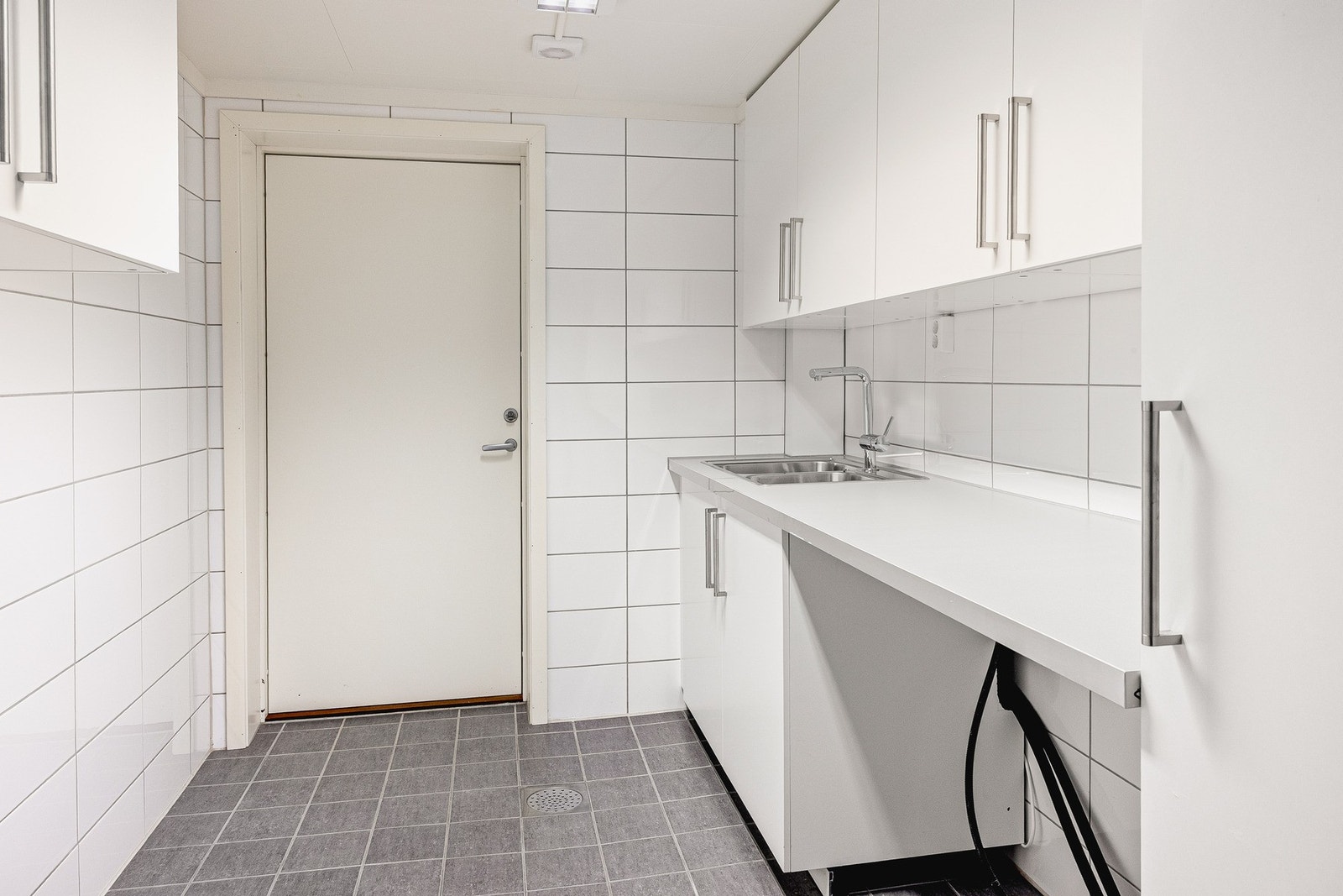 Skapinnredning med laminert benkeplate, stålvask og opplegg
for vaskemaskin. Galleribilde