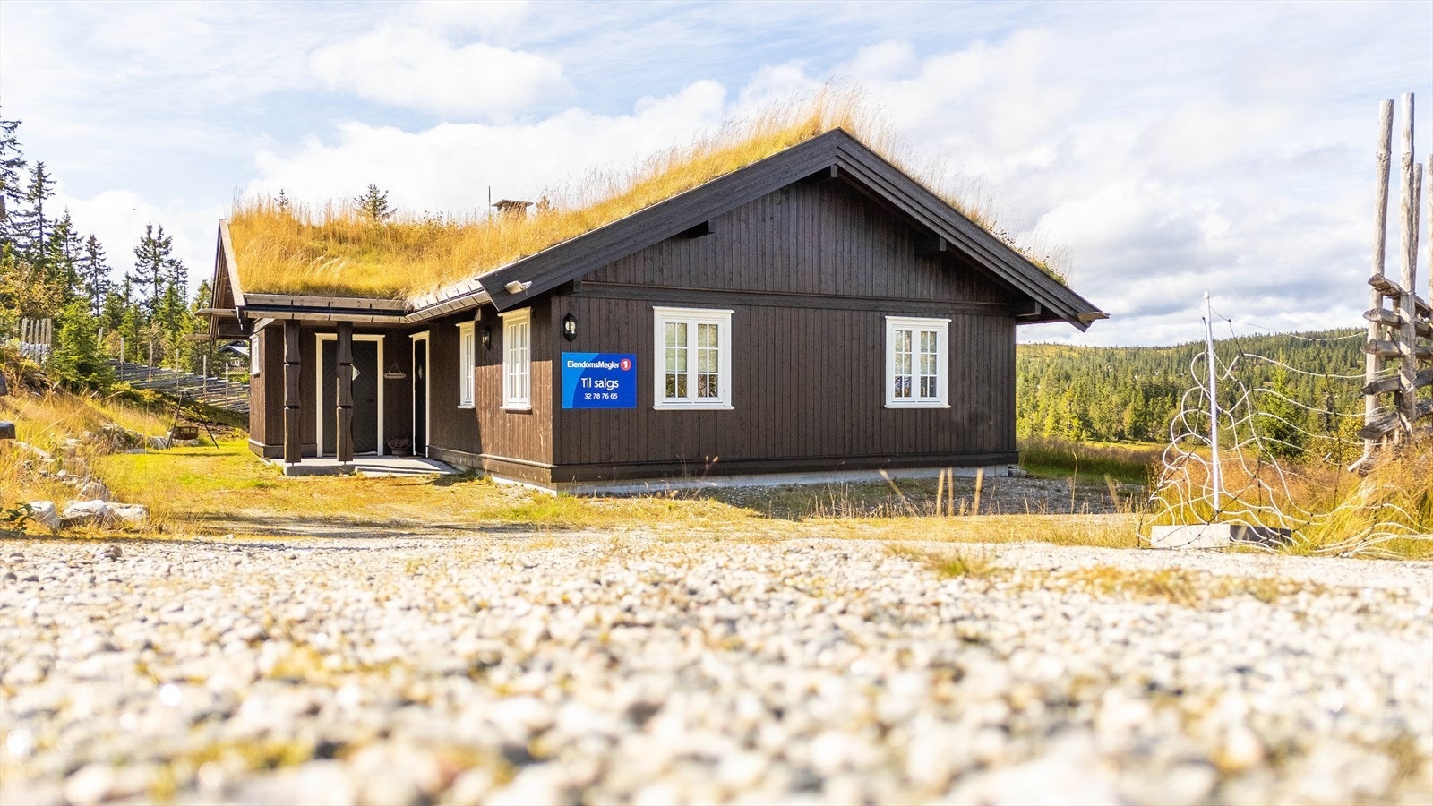 Hytta er oppført med stående bordkledning og torv på tak. Galleribilde