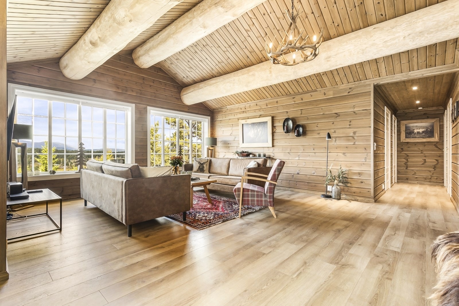 Den gode takhøyden og de runde tømmerbjelkene i taket gir rommet karakter. Galleribilde