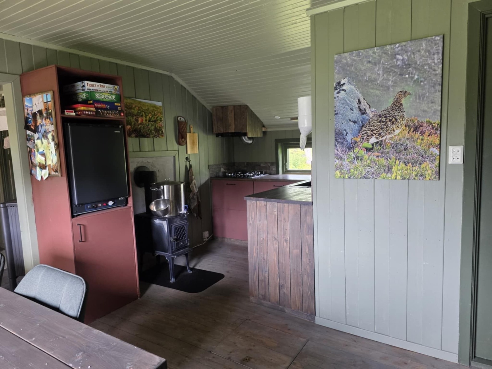 Kjøkken med gasskjøleskap, ventilator og koketopp på gass. Vedovn gir god varme i kjøkkendelen, samt varmer opp vaskevann Galleribilde