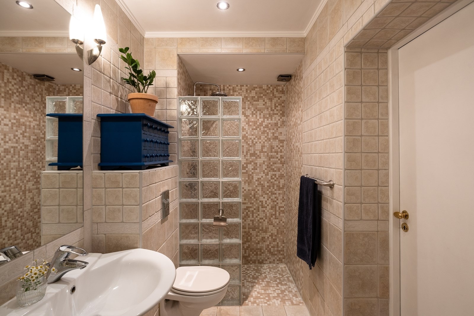 Et romslig og godt baderom med nedsenket dusjnisje, utstyrt med ny hånddusj fra 2023 og vegg i glassbyggerstein. Galleribilde