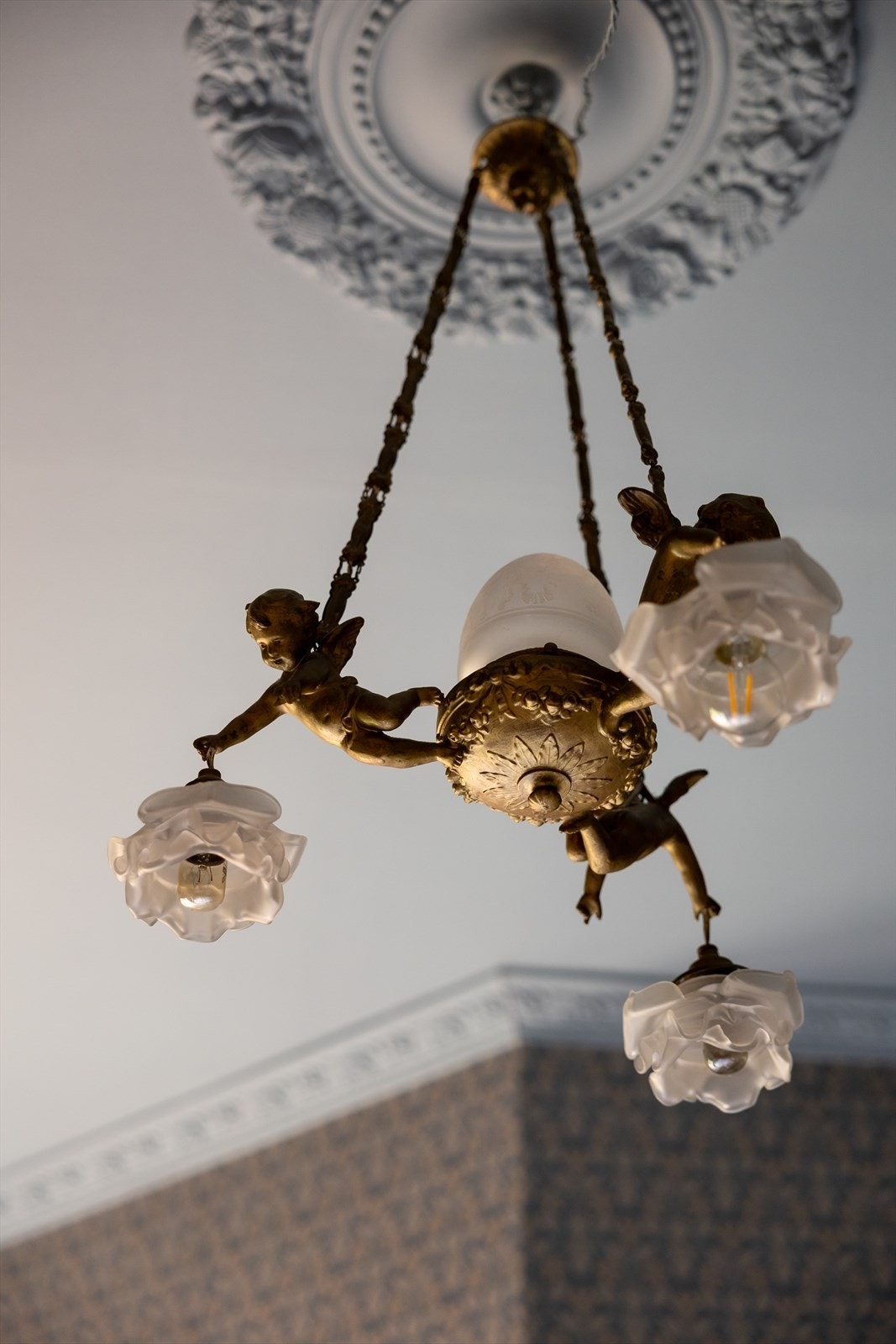 I likhet med resten av leiligheten er rommet preget av gjennomførte detaljer, med tapetet Nora fra Boråstapeter, samt elegant stukkatur og takrosett som understreker den klassiske stilen. Galleribilde