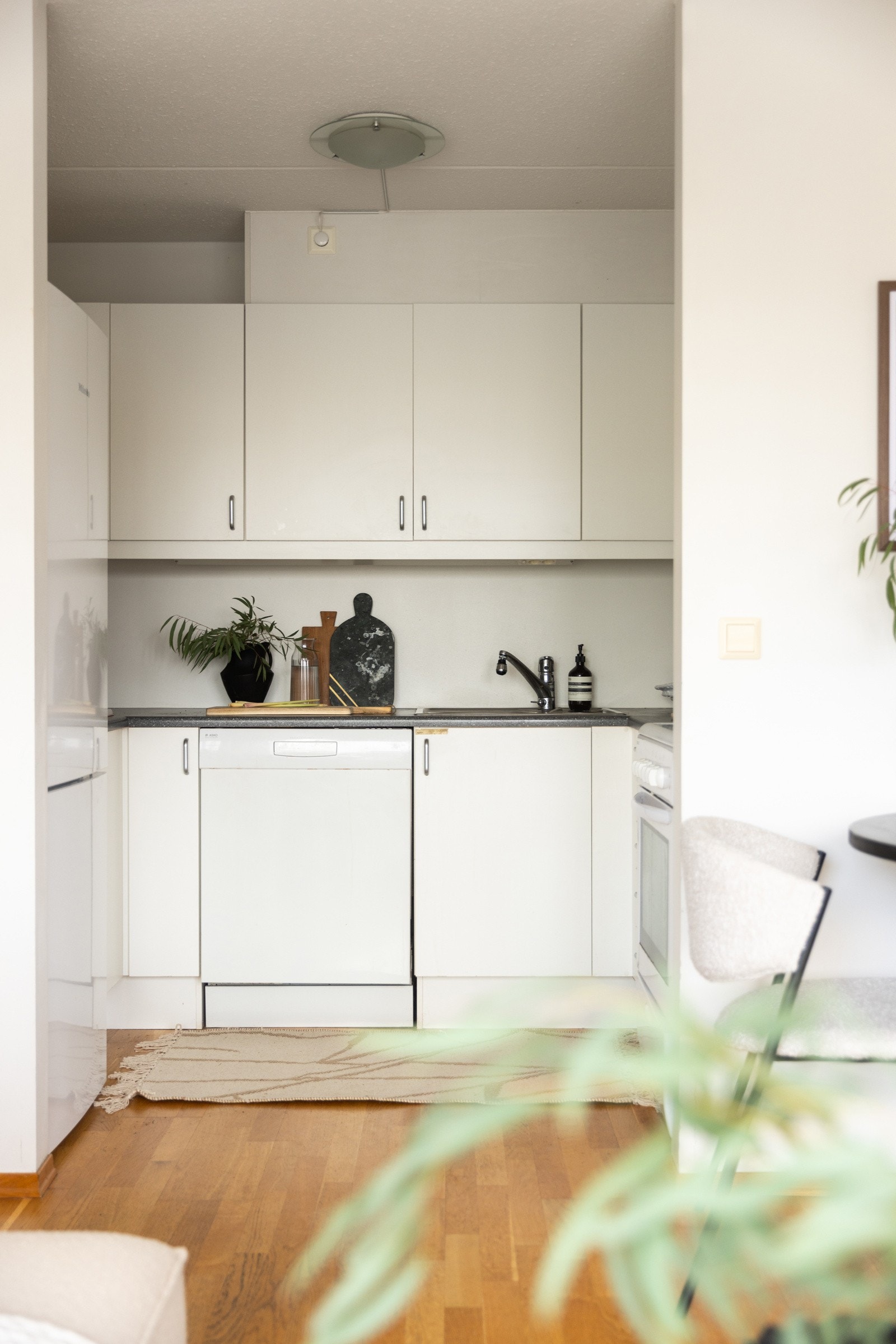 Tidsmessig kjøkken med glatte hvite fronter og benkeplater i laminat. Galleribilde