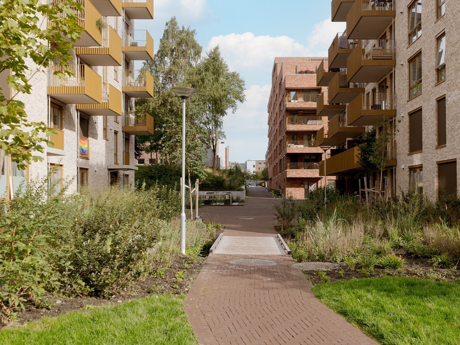 Trivelig indre gård med interne veier, beplantning, grøntområder og sitteplasser. Galleribilde