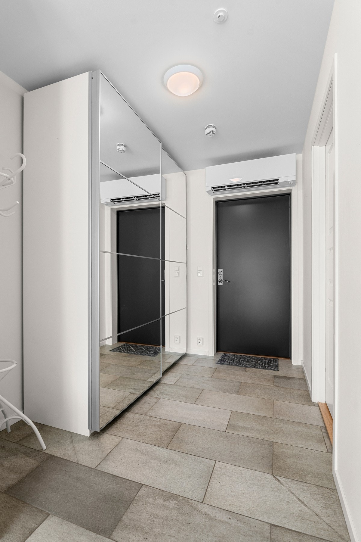 Gang med fliser på gulv og lagringsrik garderobe. Galleribilde