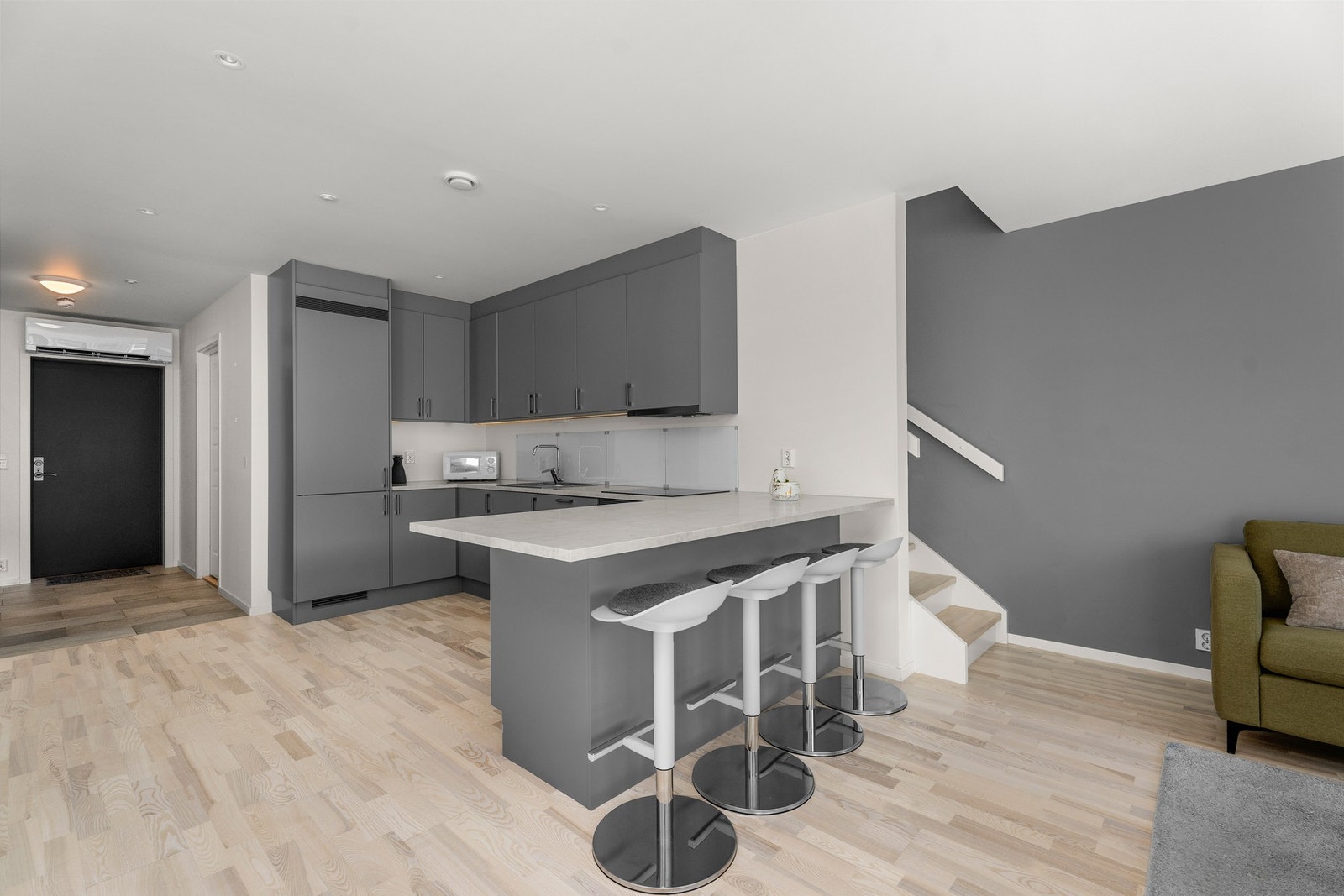 Vinkel på kjøkkenet bidrar med ekstra arbeidsplass og sitteplasser. Galleribilde