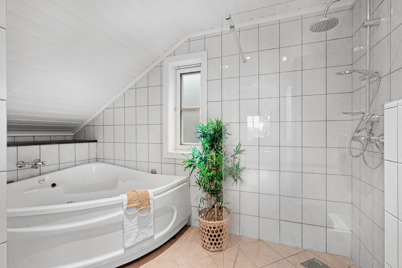 Stort hjørnebadekar i tillegg til stilig dusjløsning - gir rom for velvære og avslapning. Galleribilde