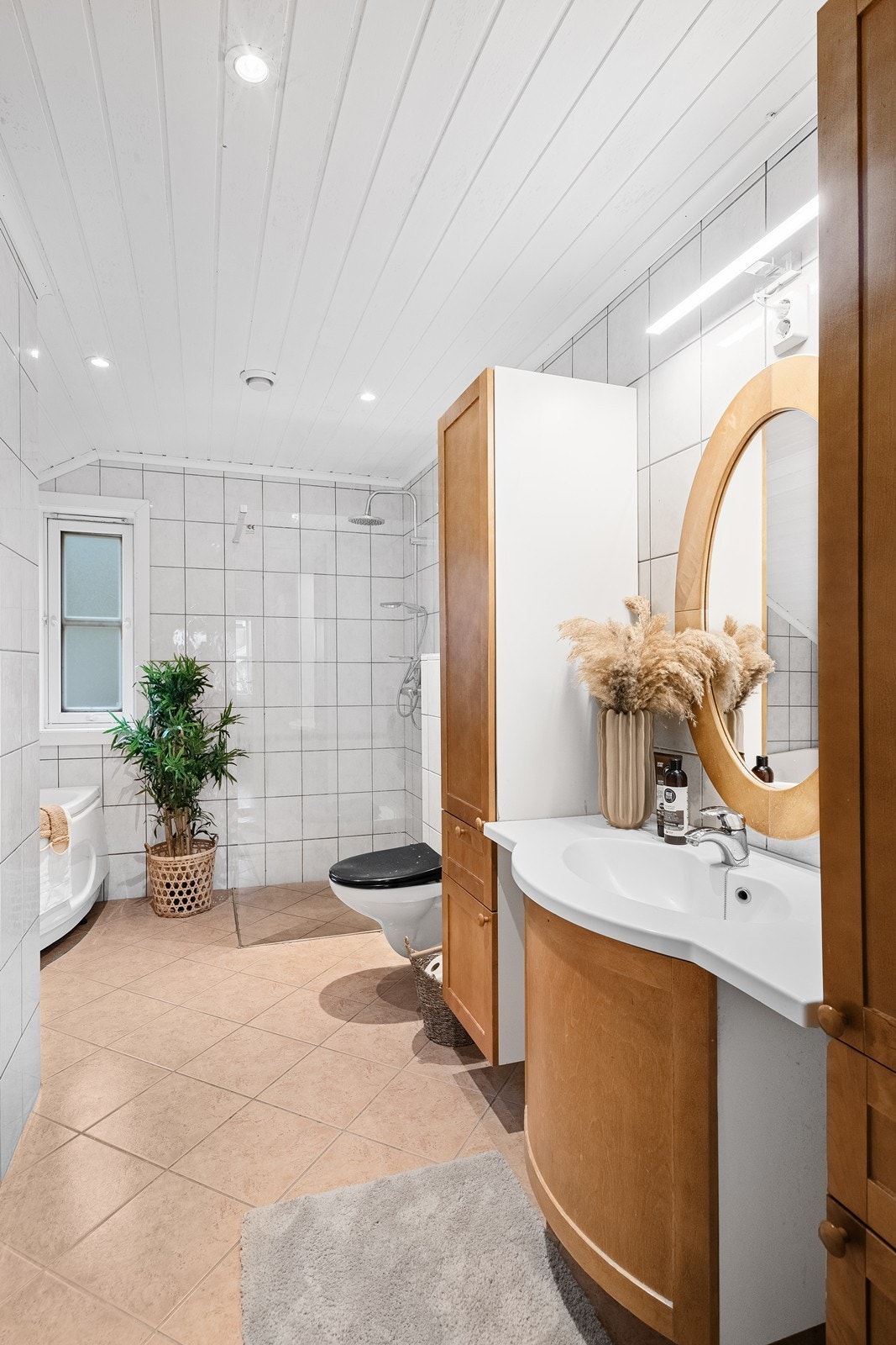 Helfliset bad med tidløst uttrykk - hvite vegger og gulv i varm fargetone. Galleribilde