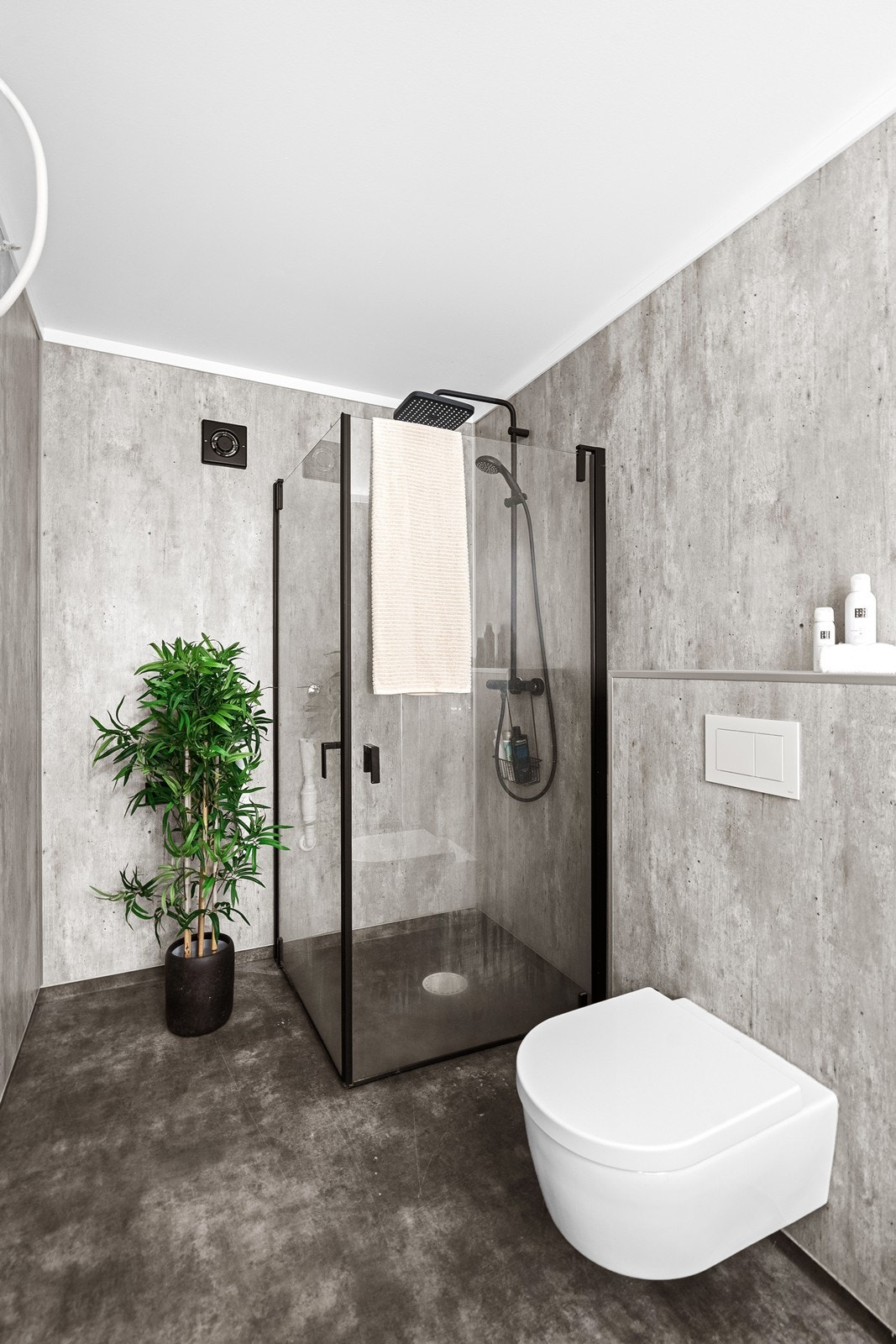 Baderom i moderne sementfarger og gjennomførte materialvalg. Galleribilde