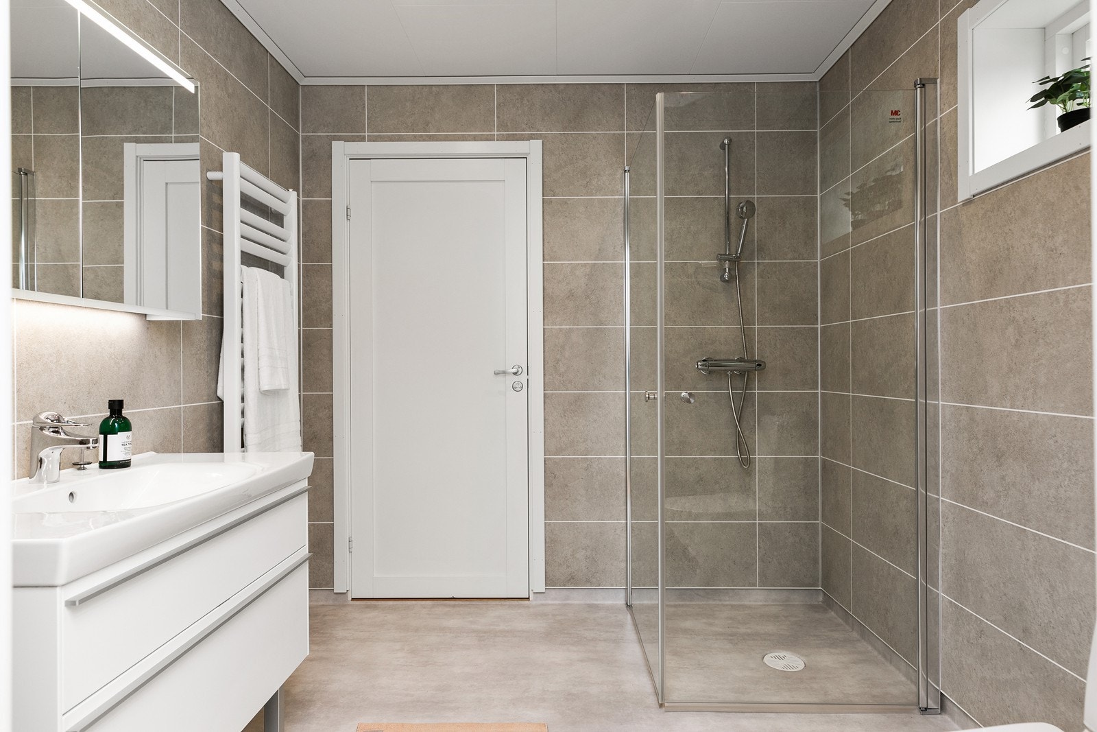 Baderommet har belegg på gulvet og våtromsplater på veggene. Det er elektrisk komfortvarme. Galleribilde