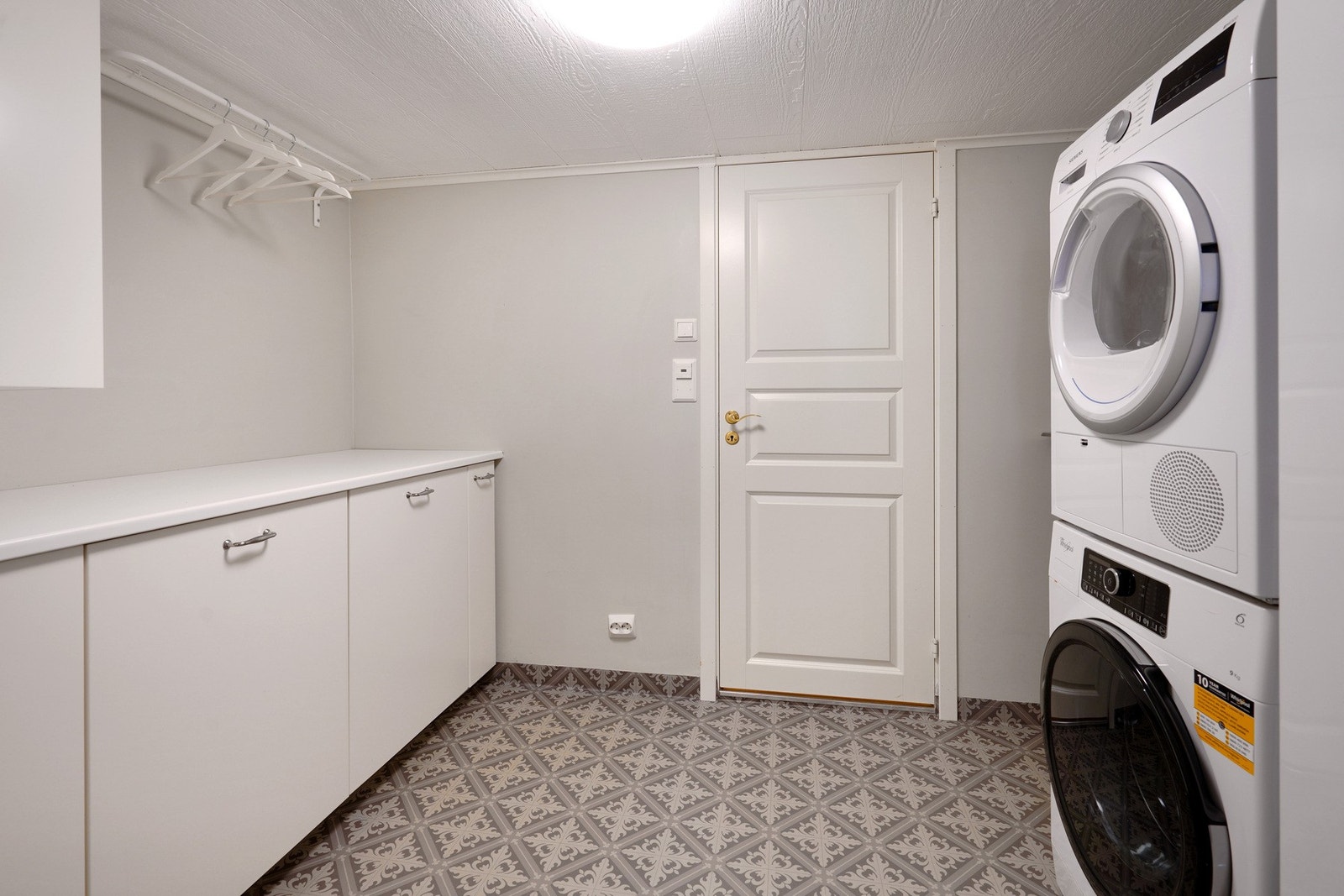 Praktisk vaskerom med opplegg til vaskemaskin og tørketrommel. Galleribilde