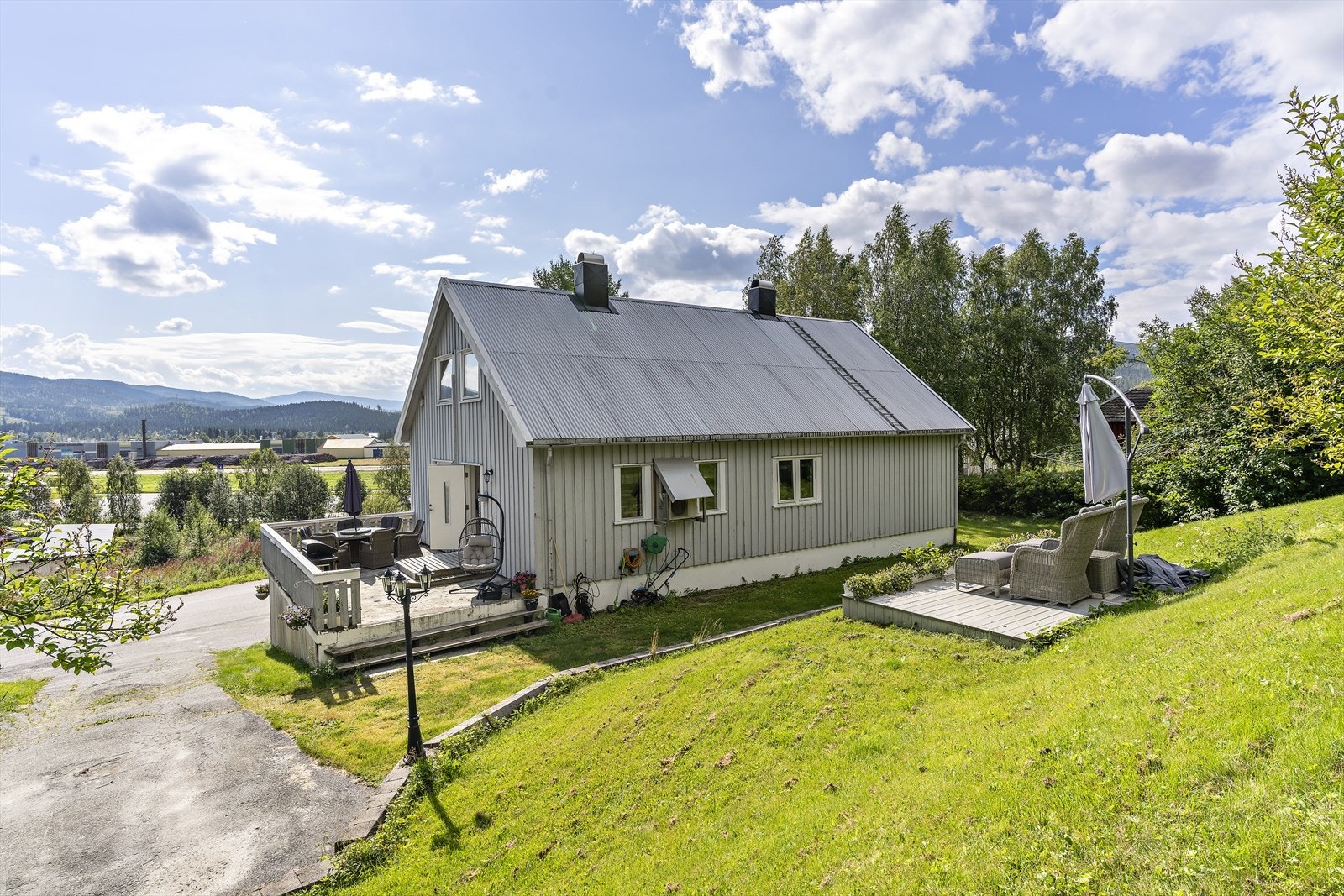 Her ser du boligen fra baksiden, inngangsparti/platt. I tillegg er det etablert en platt i skråningen. Fin plass å kose seg på fine dager. Terrasse/inngangsparti er på ca. 32 m2 Galleribilde