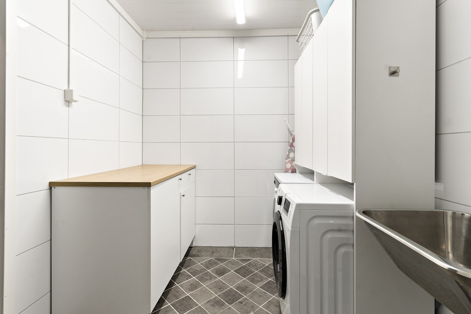 Flislagt vaskerom oppusset i 2019. Rommet har elektriske varmekabler men de er ikke tilkoblet. Ellers er det montert innredning med underskap og laminert benkeplate,
utslagsvask i stål, opplegg for vaskemaskin og VVS bereder (fra 2018). Galleribilde