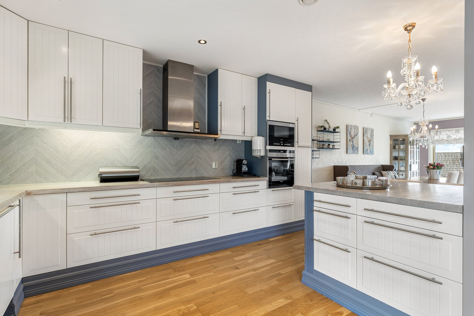 Pent kjøkken fra byggeår. Benkeplate med vaskekum og ett-greps armatur. Profilerte fronter. Benkeplate av tre. Benkeskapsbelysning og stikkontakter over kjøkkenbenk. Frittstående kjøleskap. Galleribilde