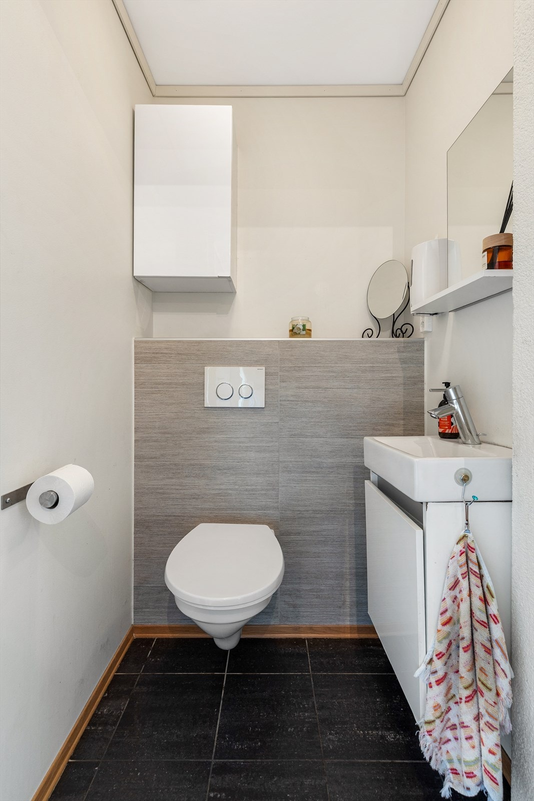 WC-rom med inngang fra entreen. Flis på gulv med varme. Servant med underskap. Vegghengt toalett. Innebygget sisterne. Vegghengt skap. Galleribilde