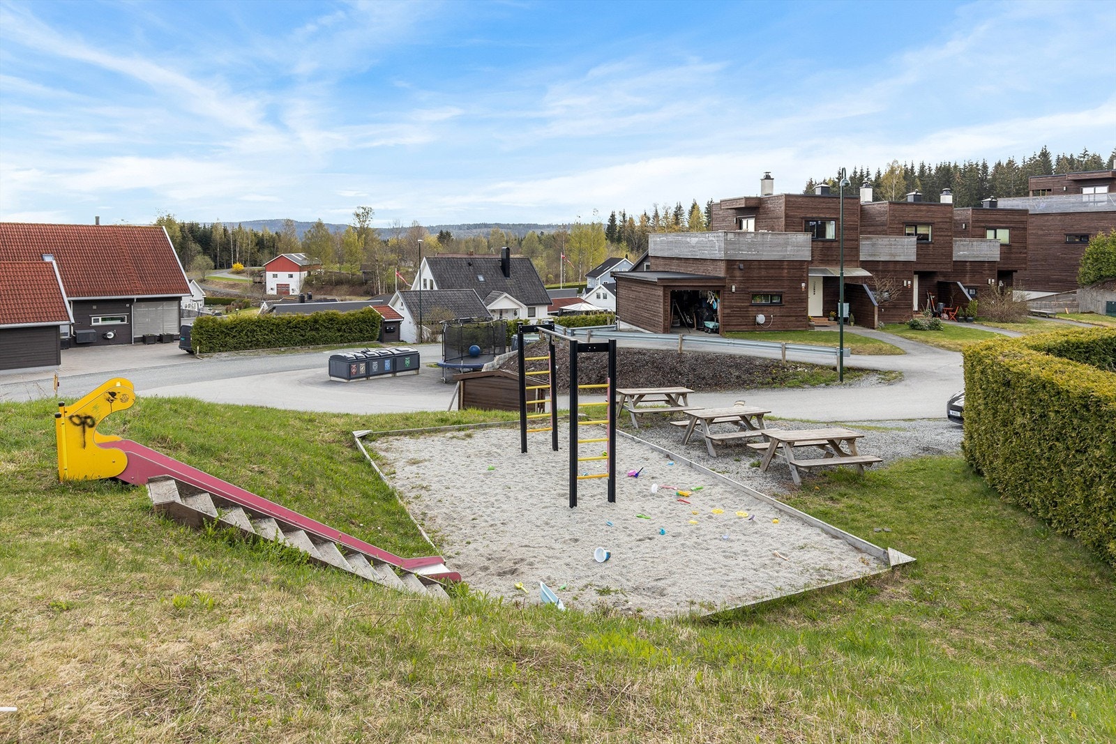 Fellesarealer opparbeidet med diverse beplantning, prydbusker, plenområder, asfaltert gårdsplass og lekeplass for barna. Galleribilde