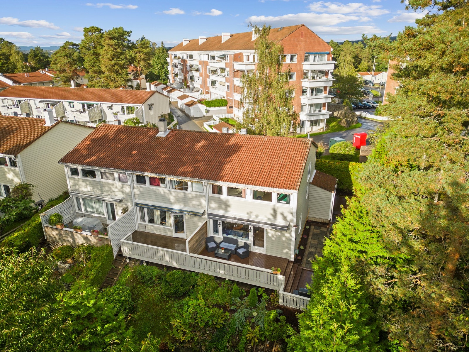 Enderekkehus med ekstra gode uteområder, omkranset av frodig vegetasjon som gir både privatliv og en skjermet atmosfære. Galleribilde