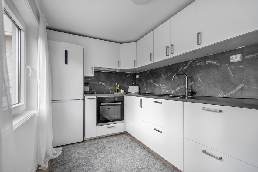 Pen kjøkkeninnredning i hybel med god benk- og skapplass Galleribilde