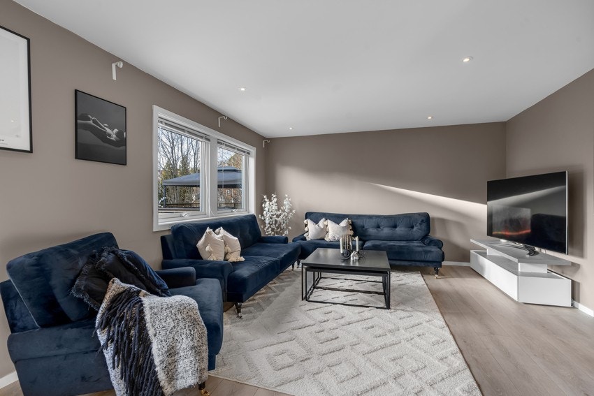 Romslig stue med store vinduer som gir mye naturlig lys Galleribilde