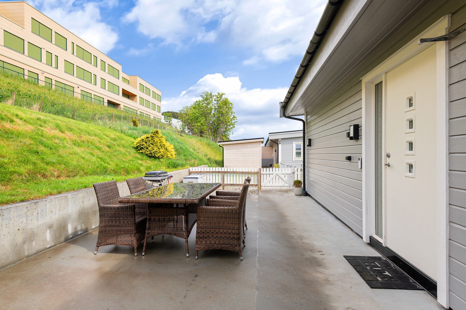 Moderne uteplass i betong med spisegruppe og grill. Galleribilde