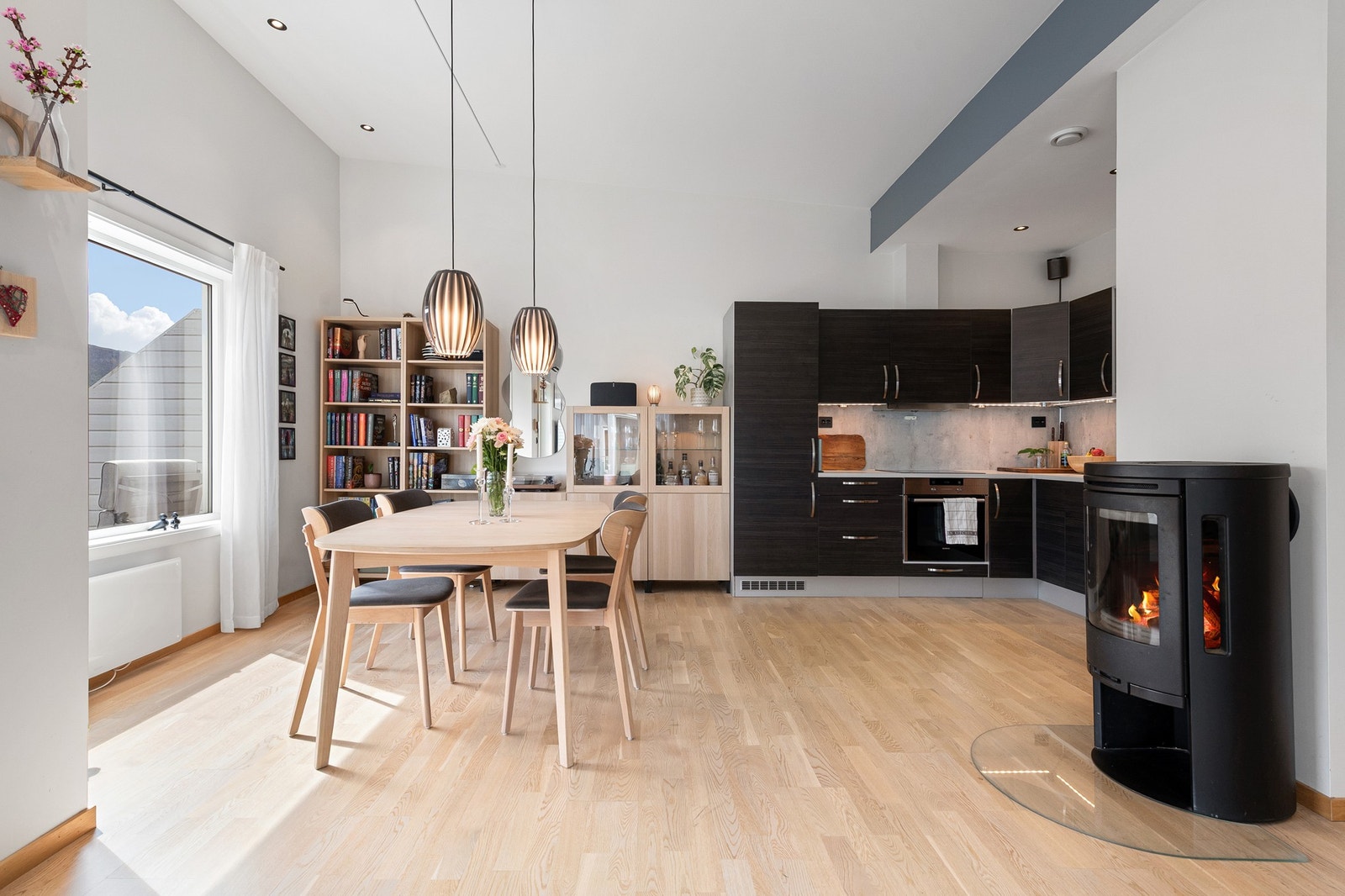 Lys og moderne kjøkkenløsning med peis. Perfekt for hyggelige sammenkomster. Store vinduer gir naturlig lys og luftig atmosfære. Galleribilde