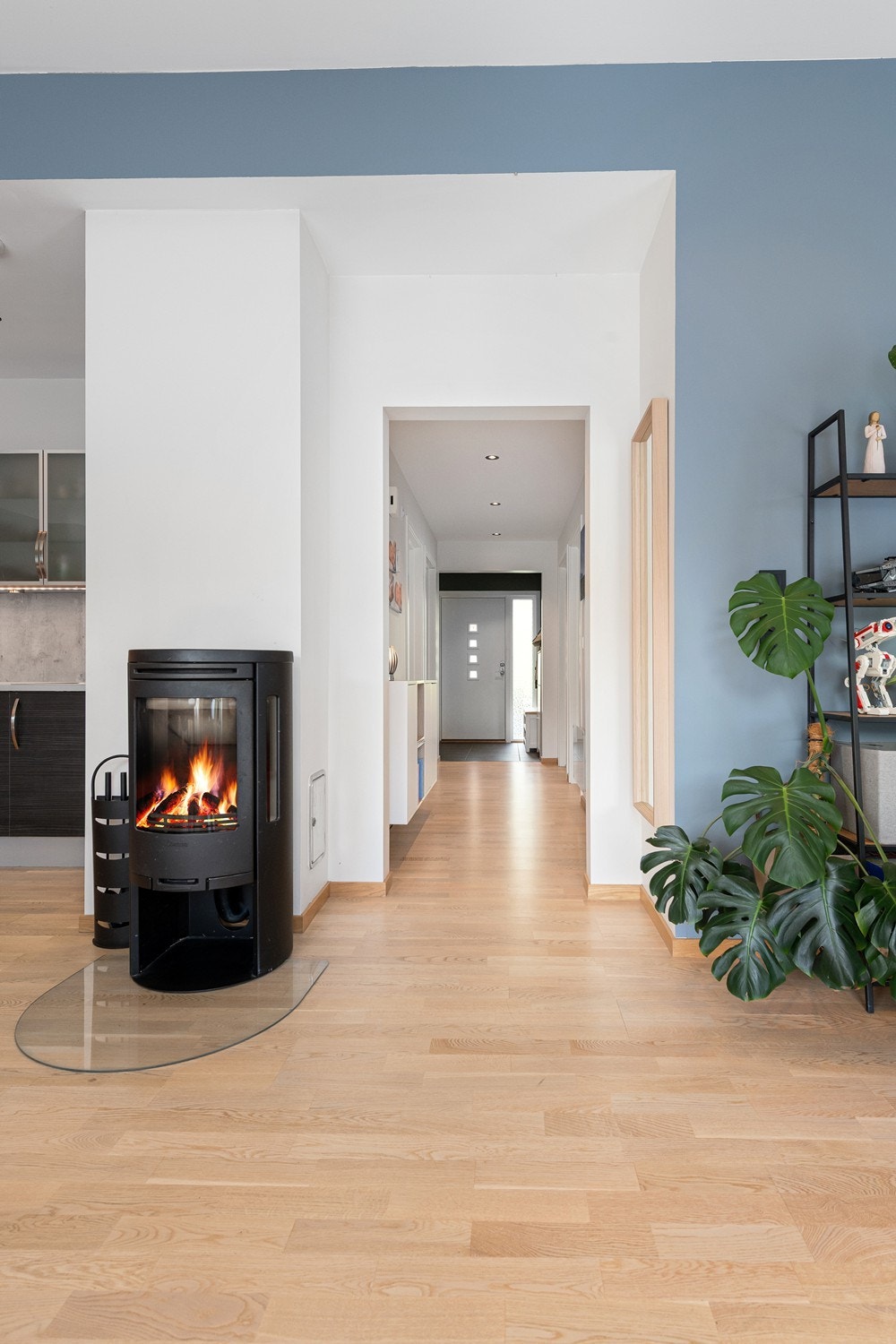 Lys og innbydende gang med moderne peis og stilrene detaljer. Perfekt for en varm og koselig atmosfære. Galleribilde