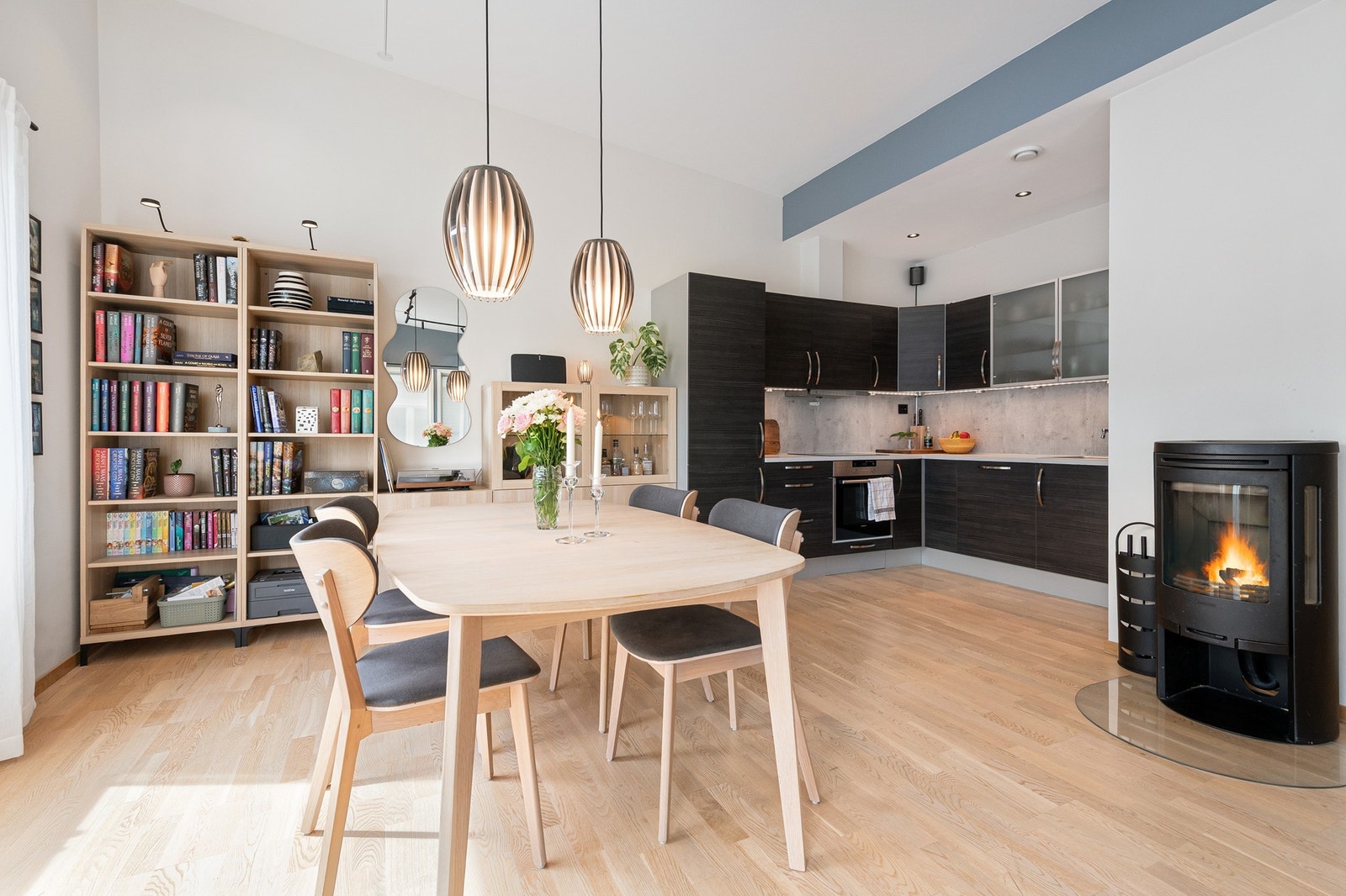 Lys og moderne leilighet med åpen planløsning, stilren kjøkkenløsning og peis som skaper en innbydende atmosfære. Galleribilde