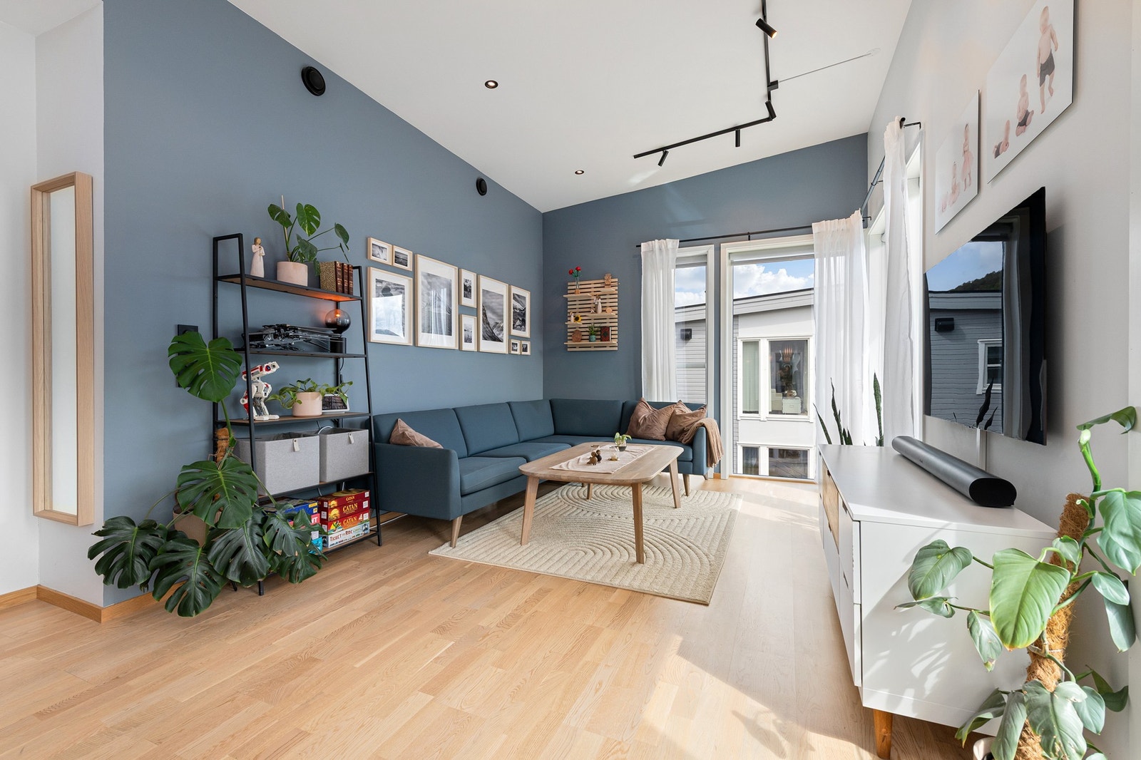 Lys og moderne stue med store vindusflater som slipper inn mye naturlig lys, gir en innbydende atmosfære. Galleribilde