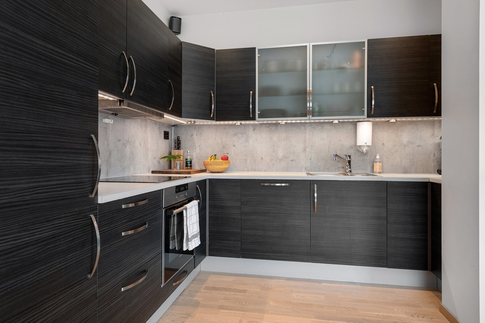 Moderne og stilrent kjøkken med mørke fronter og gode arbeidsflater, perfekt for matlaging og sosiale sammenkomster. Galleribilde