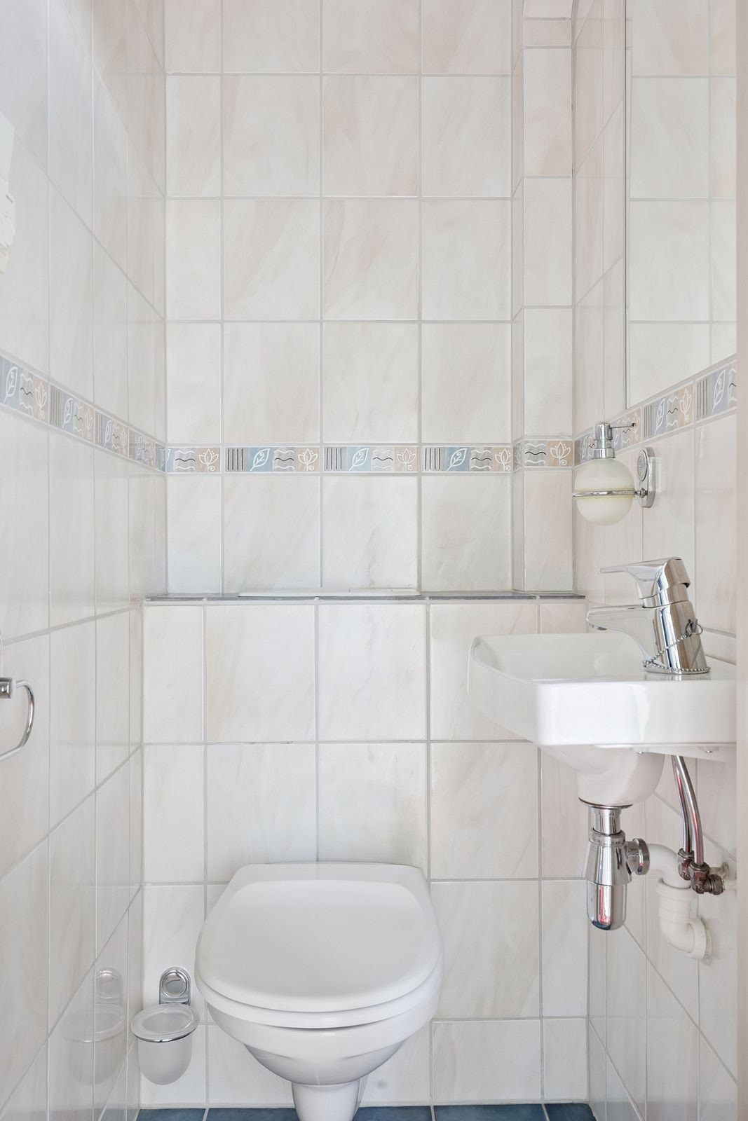 Ved kjøkkeninngangen ligger et praktisk toalettrom, pent flislagt og utstyrt med wc og servant. Galleribilde