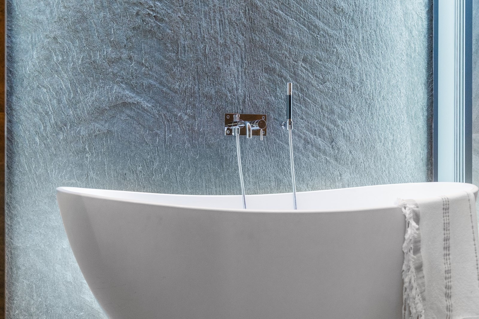 I det frittstående badekaret kan man ta seg en velfortjent "timeout". Her er bygningskroppen utkraget, noe som gir en omramming av vinduer i taket og på hver side av badekaret. Man har utsikt mot sjøen og takvinduet slipper himmelen inn i rommet. Galleribilde