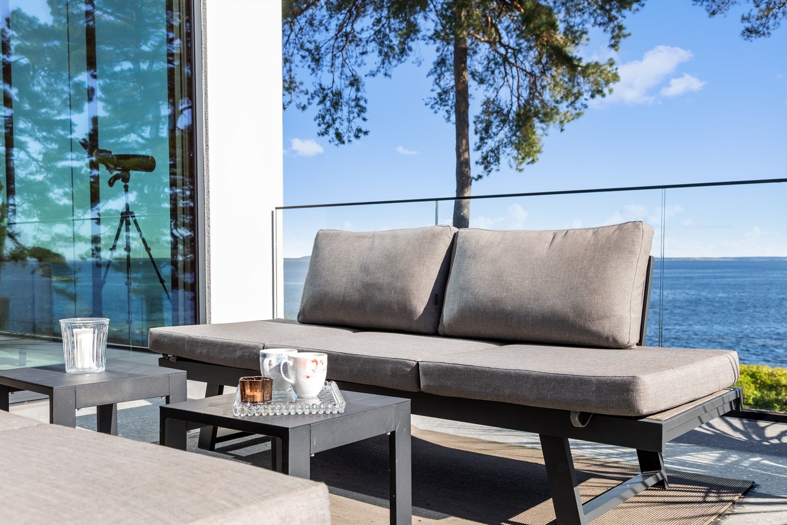 De store skyvedørene fra både stuen og kjøkkenet sørger for en sømløs overgang mellom inne-og-ute. Galleribilde