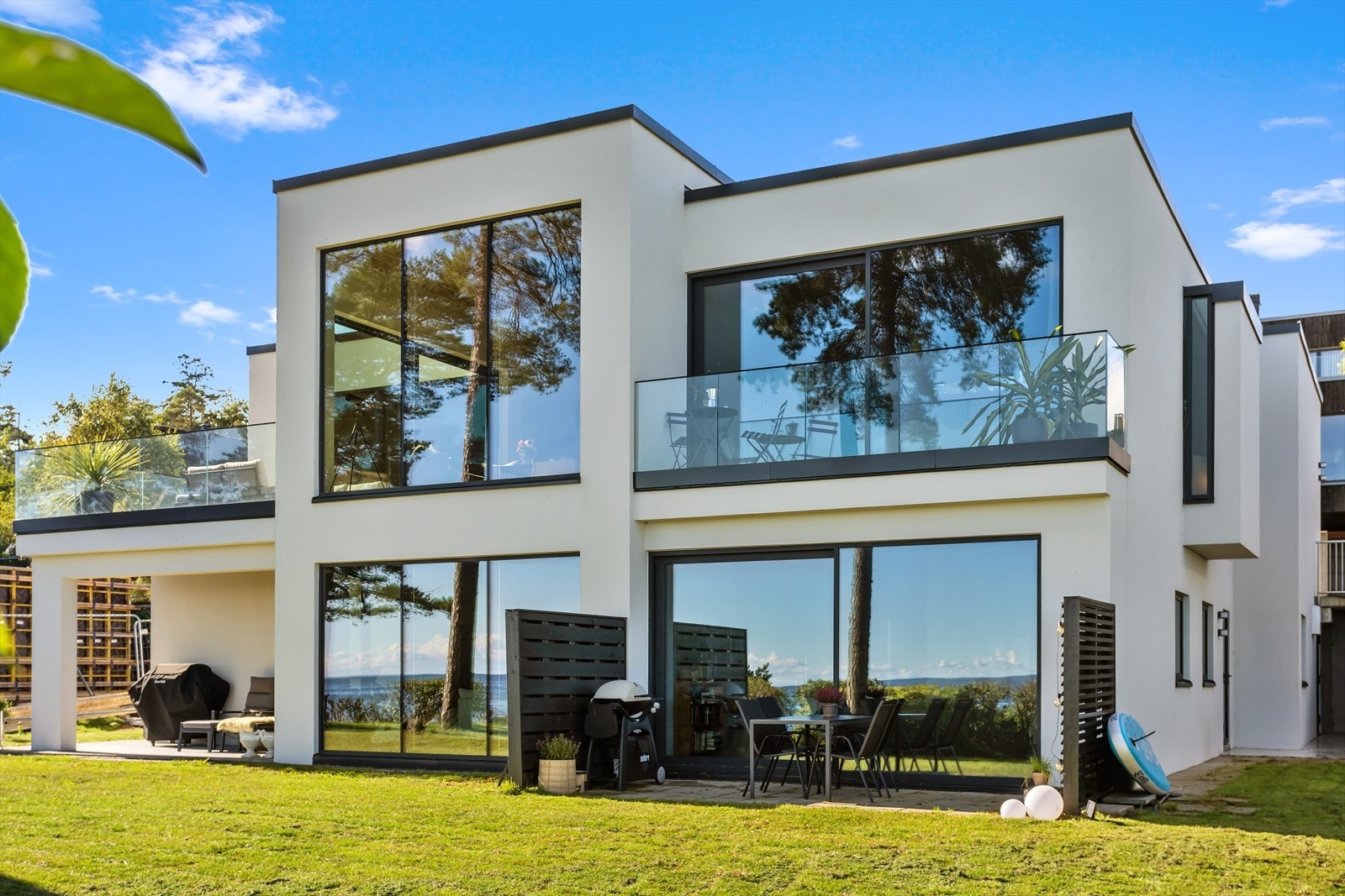 Villaen, som stod klar i 2020, er et åpent, luftig og transparent hjem. Høye himlinger særpreger de fleste rom. Store glassflater som åpnes og lukkes etter behov gjør at de sosiale sonene flyter over i hverandre, både inne og ute. Galleribilde