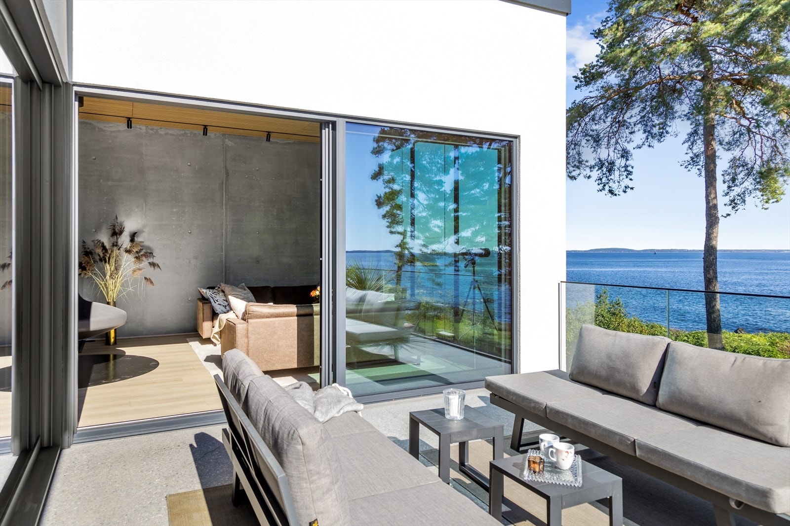 Det gjennomførte designet inne er også videreført utvendig. Legg merke til de rene linjene med rekkverk bestående av kun glass og diamantlipt betongdekke iblandet farge og stein. Galleribilde