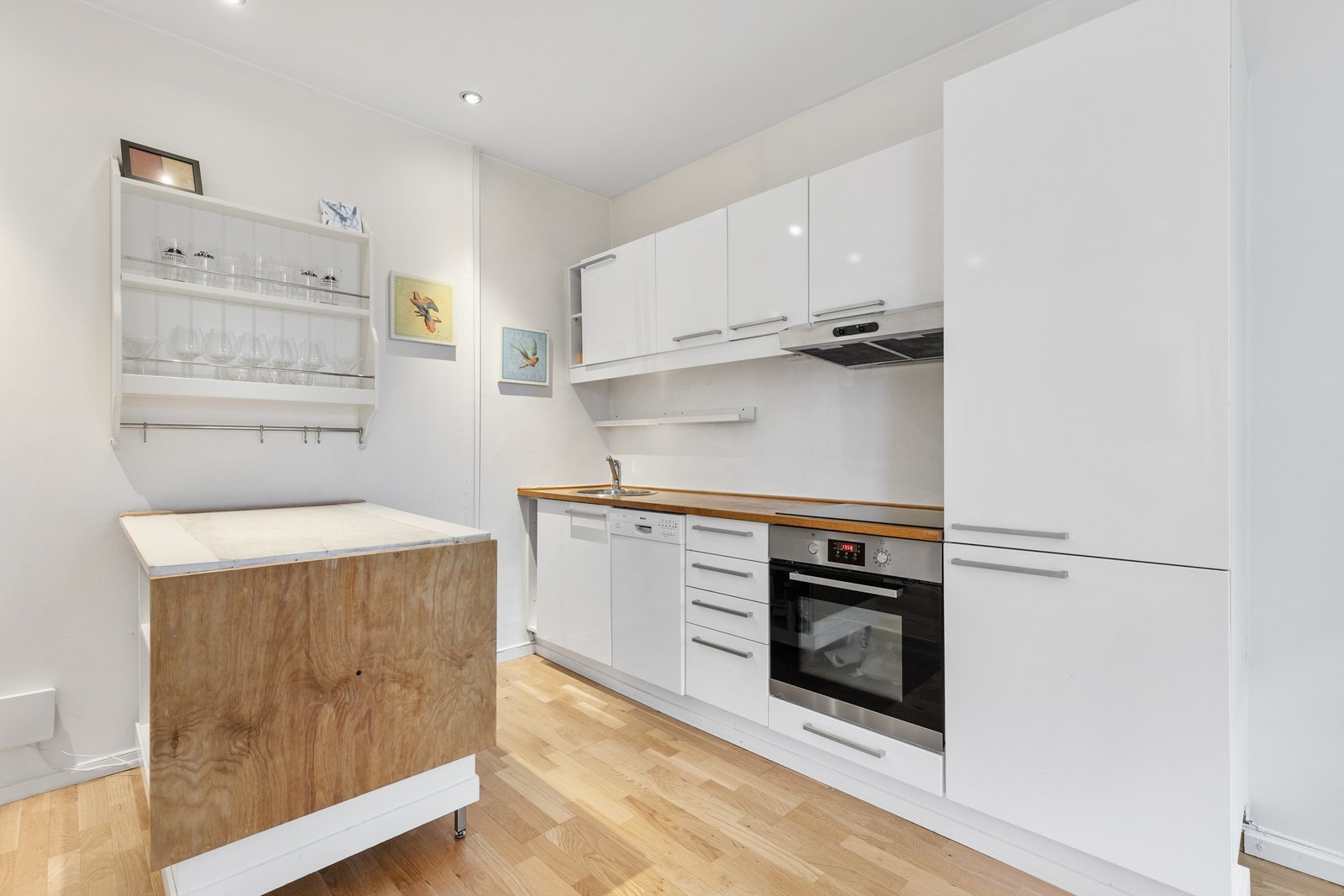 Hvitevarene er sømløst integrert og består av stekeovn med platetopp og kjøleskap med frysedel. Det er opplegg for oppvaskmaskin. Galleribilde