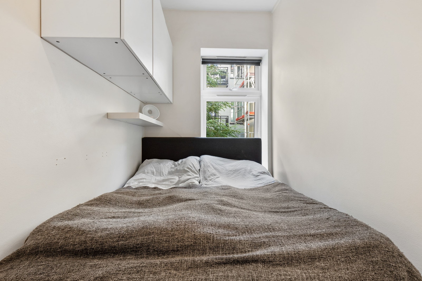 Videre er det også oppbevaring i vegghengte overskap og med vegghengt nattbord har man det man trenger. Galleribilde