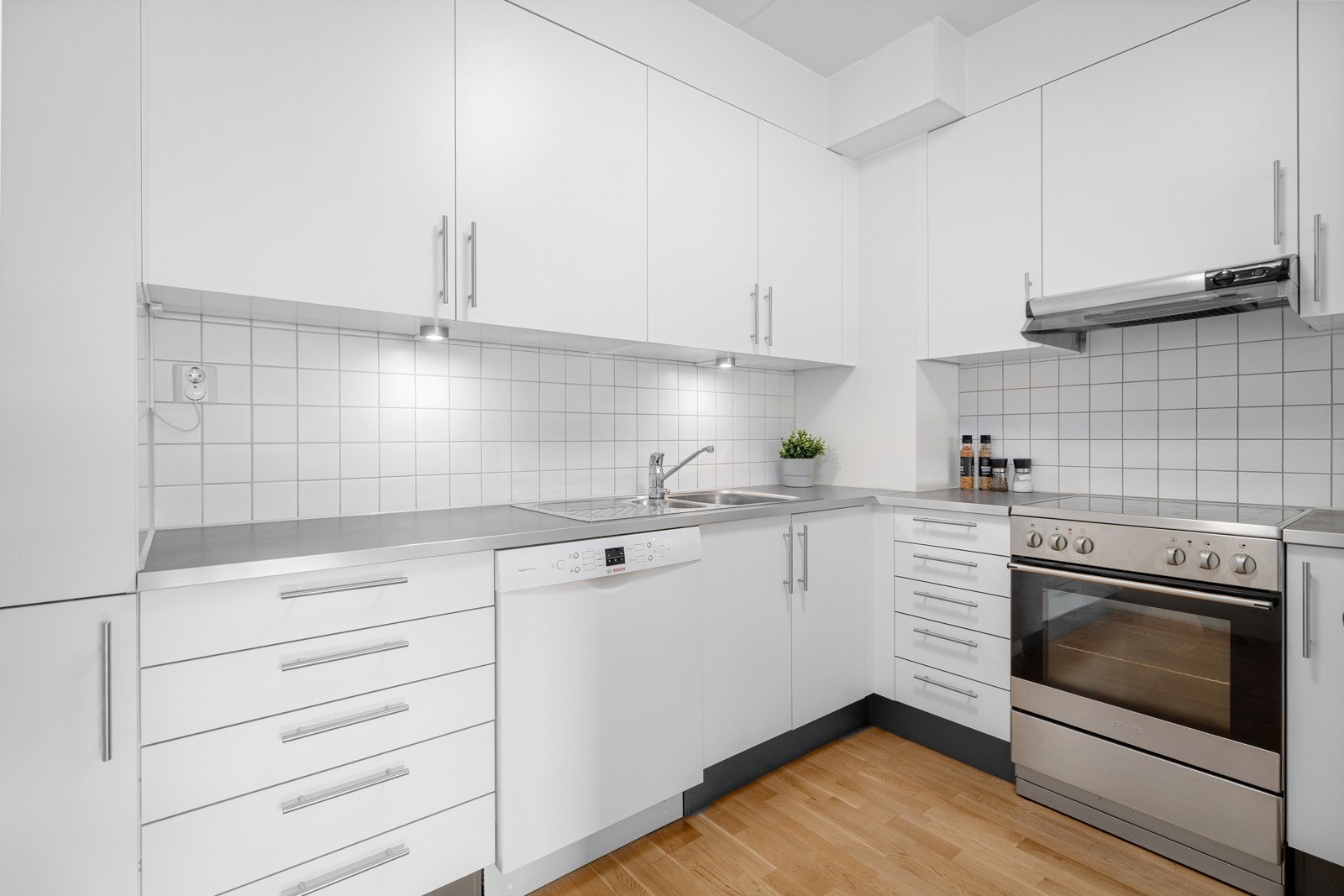 Innredet med lyse, glatte fronter, benkeplate av laminat og nedfelt kum i rustfritt stål. Galleribilde