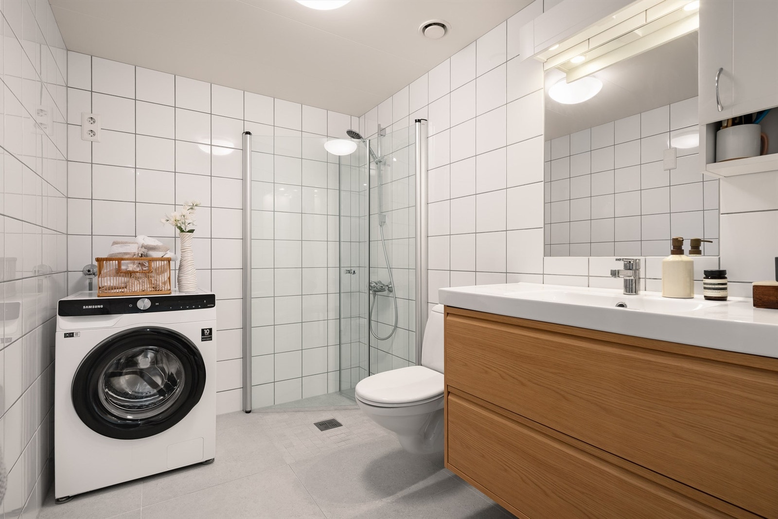 Badet er pent flislagt på gulv og vegger med vannbåren varme. Det ble lagt ny flis på flis i 2025. Galleribilde