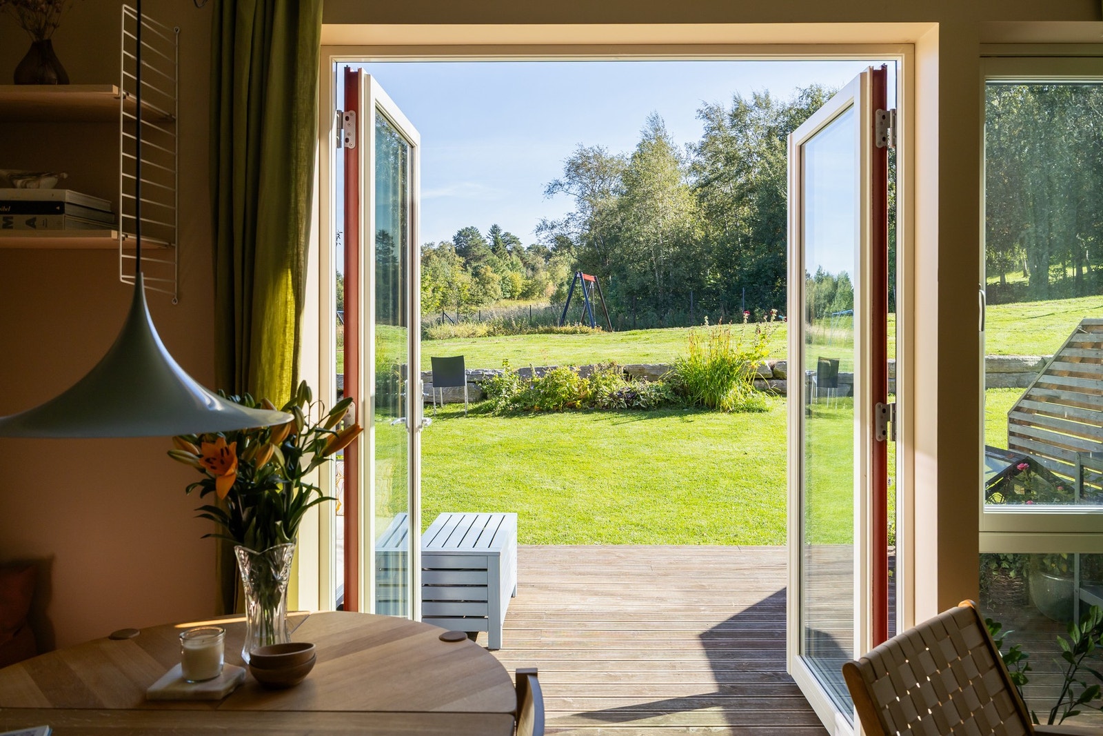 Nydelig atmosfære fra glasskledd stuevegg ut mot en privat markterrasse og plenareal. Galleribilde