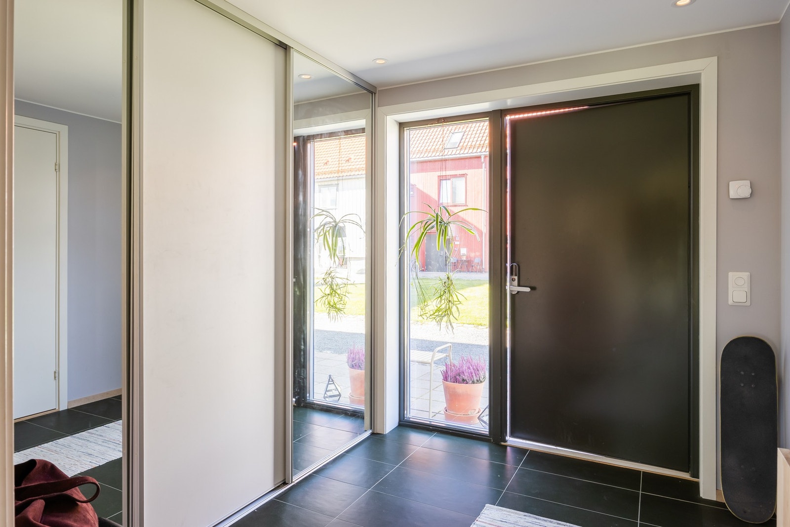 Innbydende entré med vid skyvedørsgarderobe med speilfronter, slitesterk flis på gulvet med varme, og glassnisje for naturlig innlys. Galleribilde